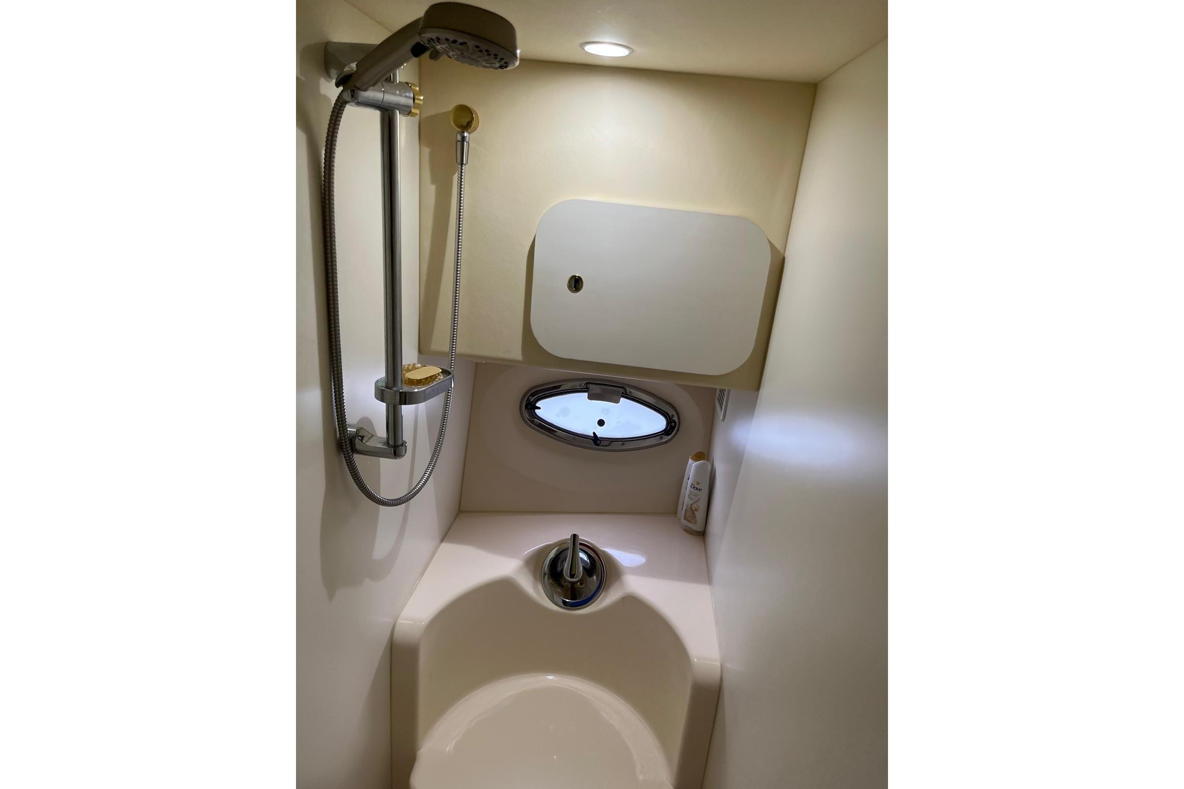 Bathroom interior of 2005 Silverton 34 Convertible yacht with shower and porthole.