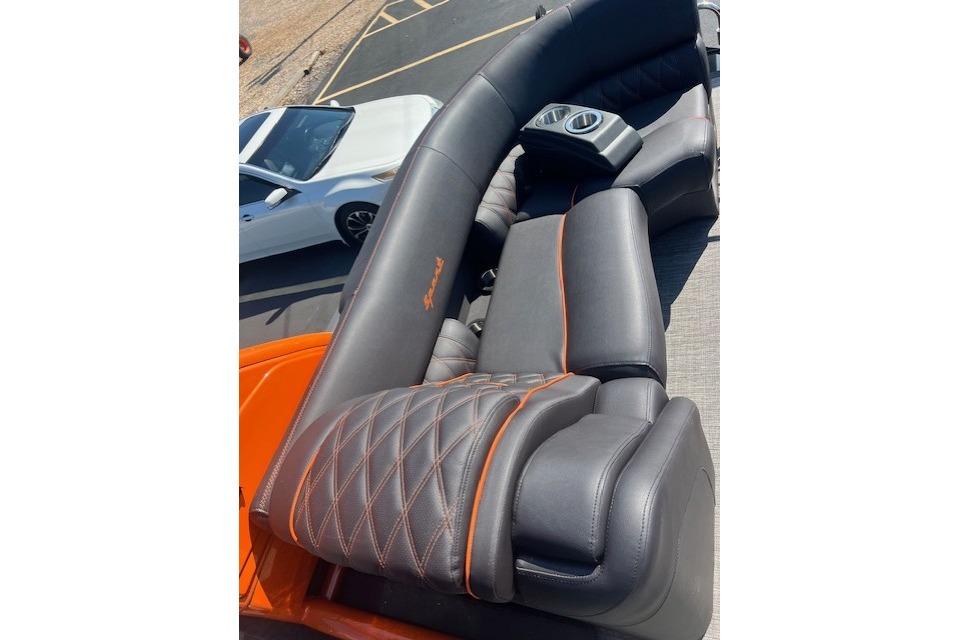 Luxurious seating on 2024 Bennington 23 RXFBA boat with orange accents and cup holders.
