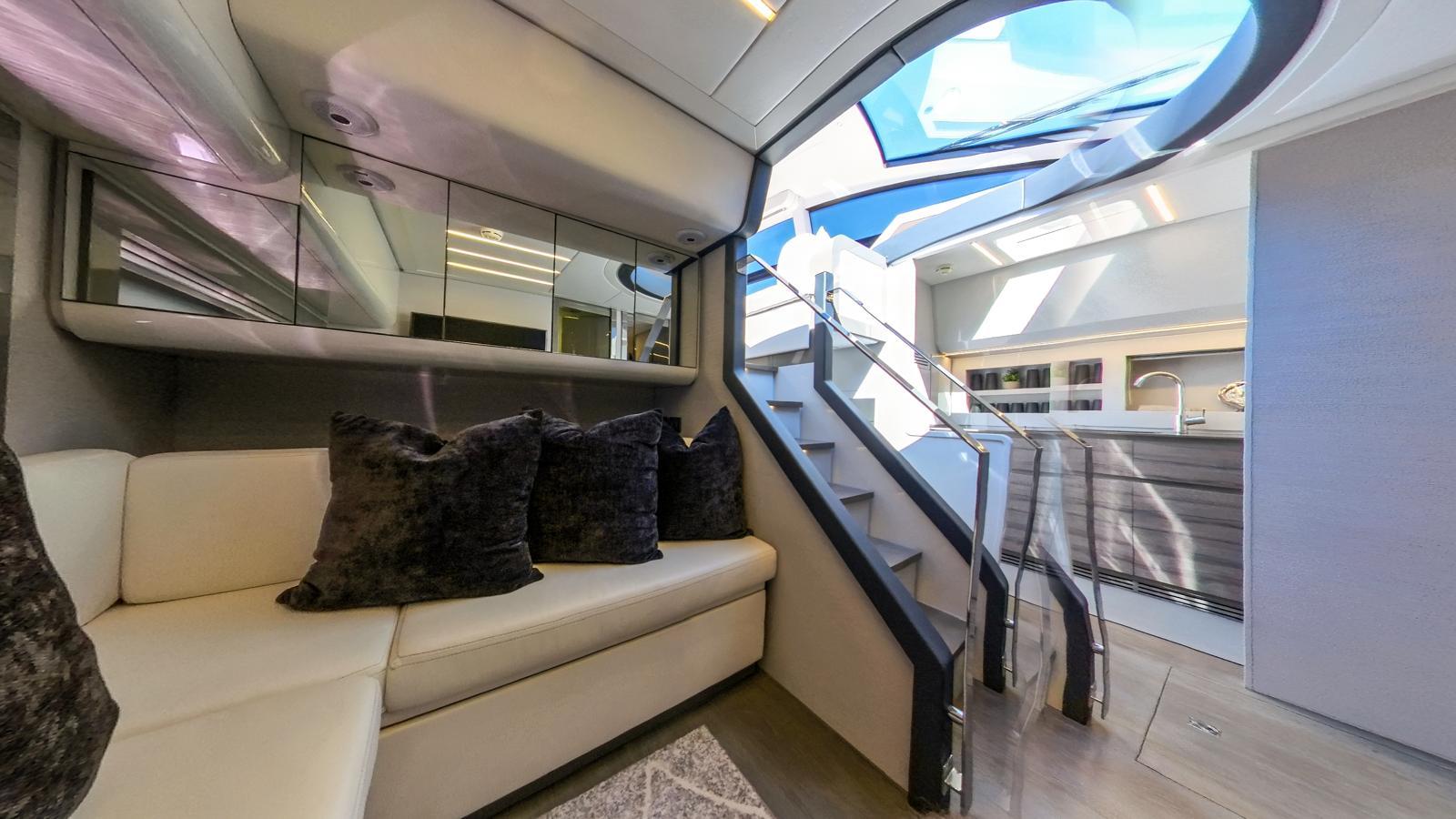 Luxurious interior of a 2014 Pershing 62 yacht with modern seating and skylight.