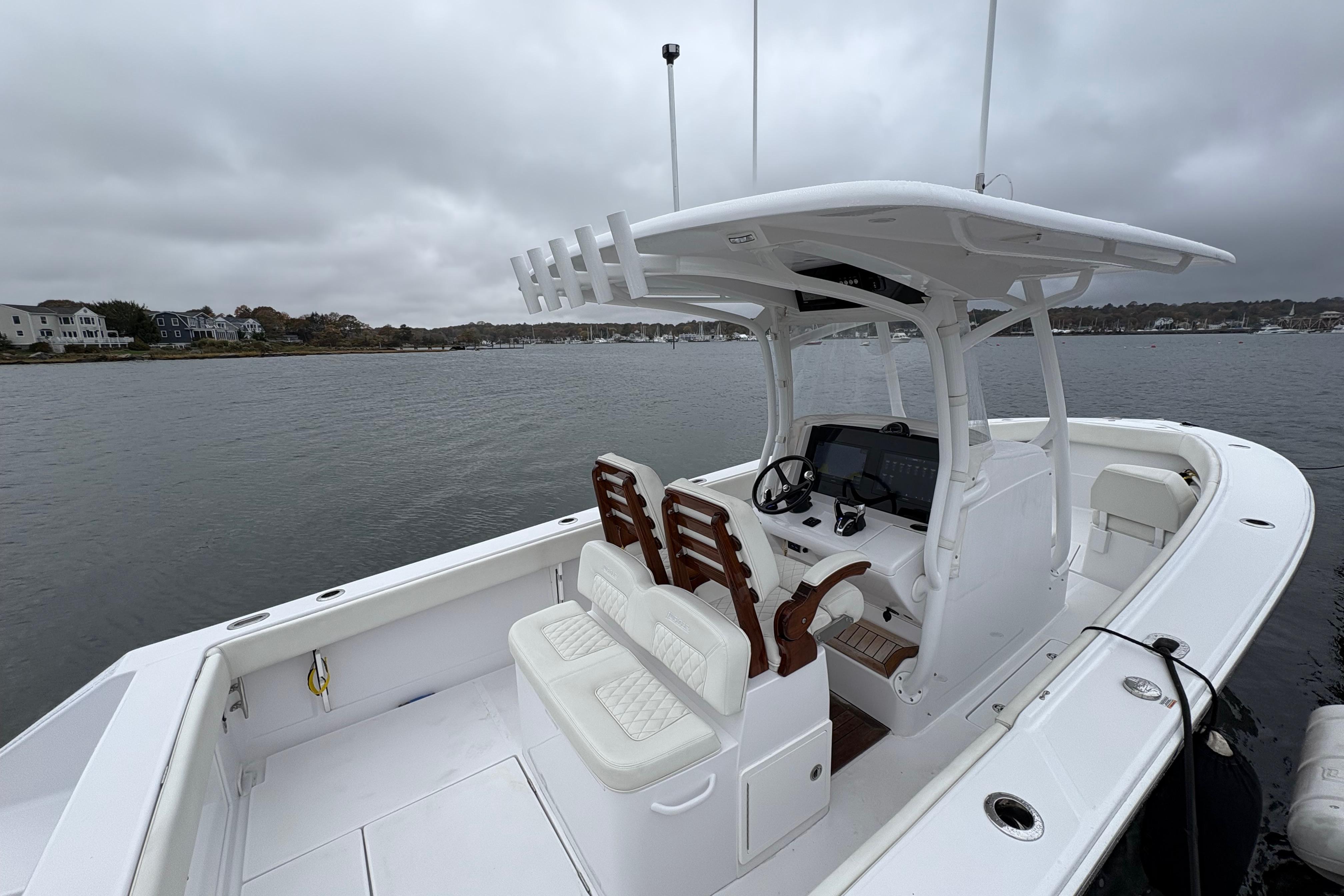 2023 Jupiter 30 boat with dual seats and console on a cloudy day.