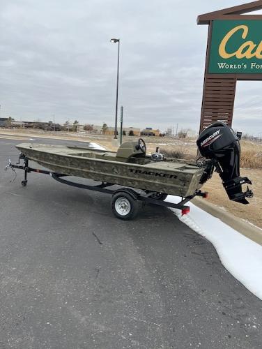 2025 Tracker Grizzly 1648 SC boat on trailer, parked near Cabela's sign.