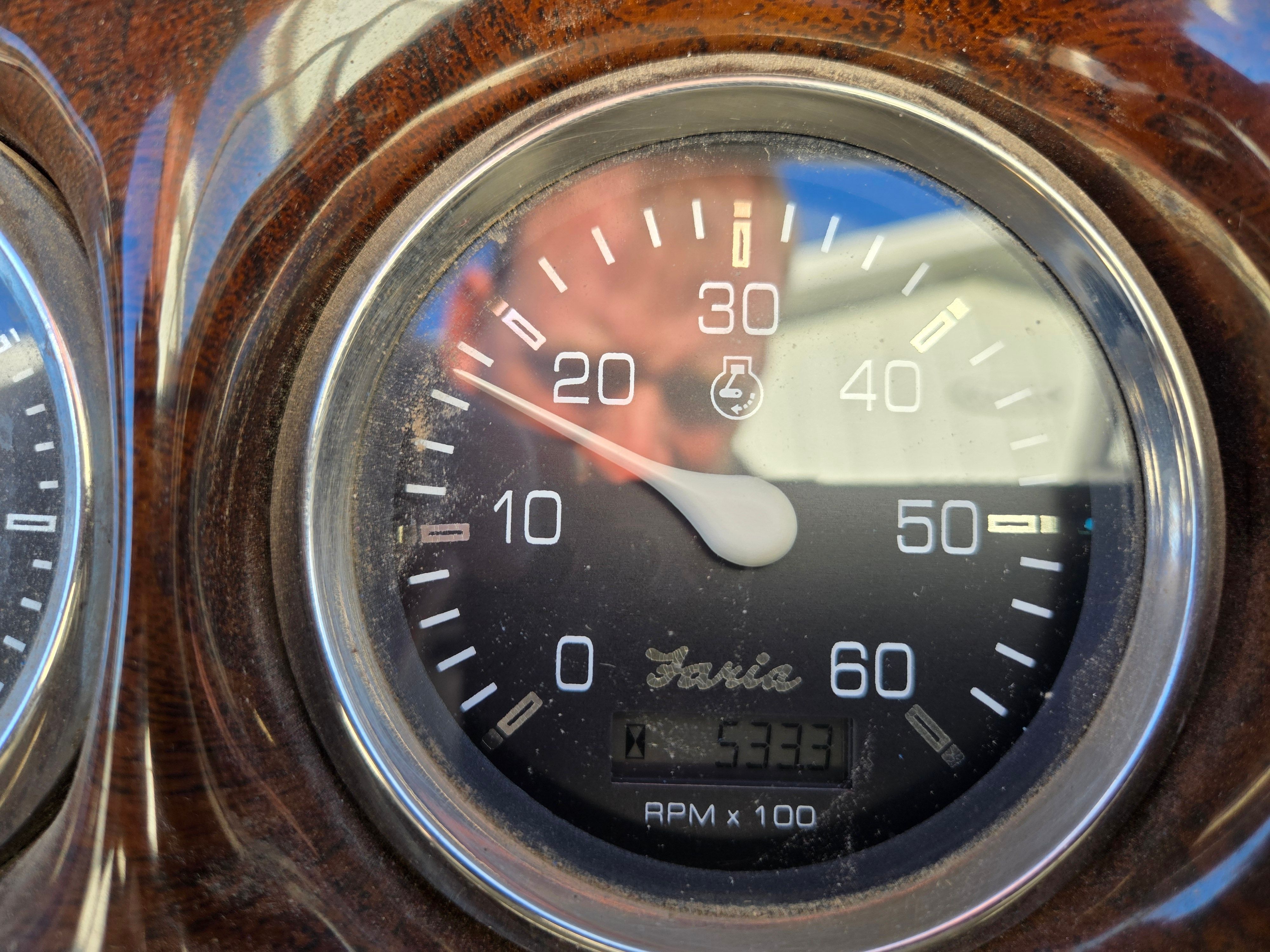 Close-up of a tachometer with a scale up to 60. The needle points to 20.