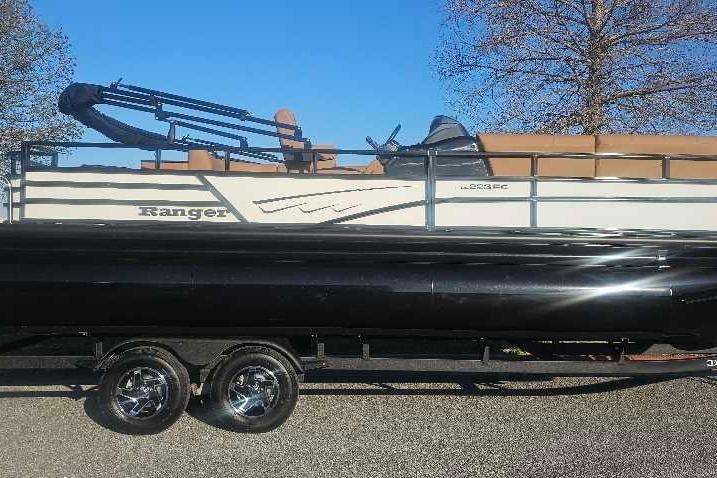 2026 Ranger 223FC pontoon boat on trailer, side view with trees in background.