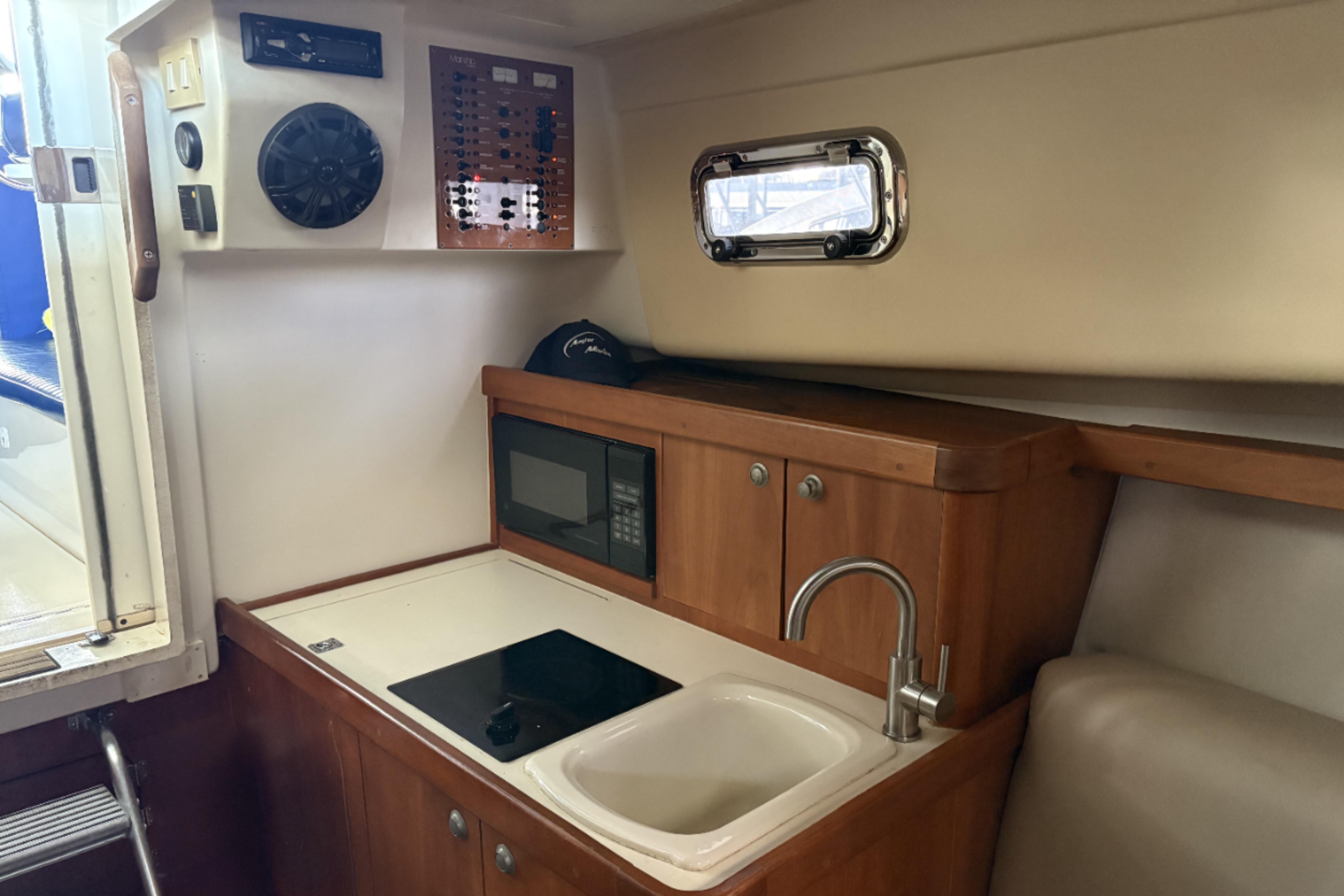 2003 Mainship Pilot 30-II interior with kitchenette, sink, and microwave.