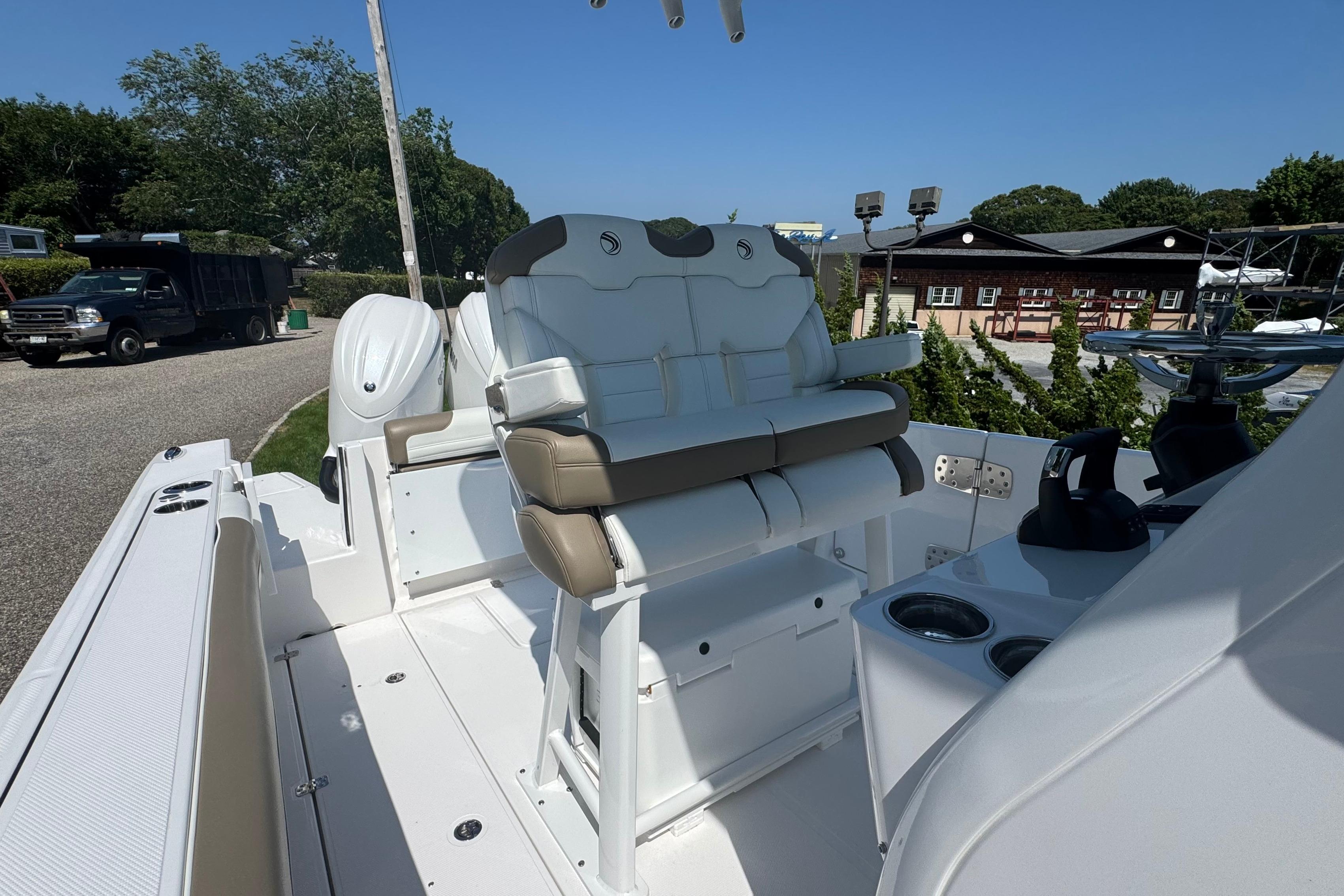 2026 Edgewater 250CC boat interior with seating and console, parked outdoors.