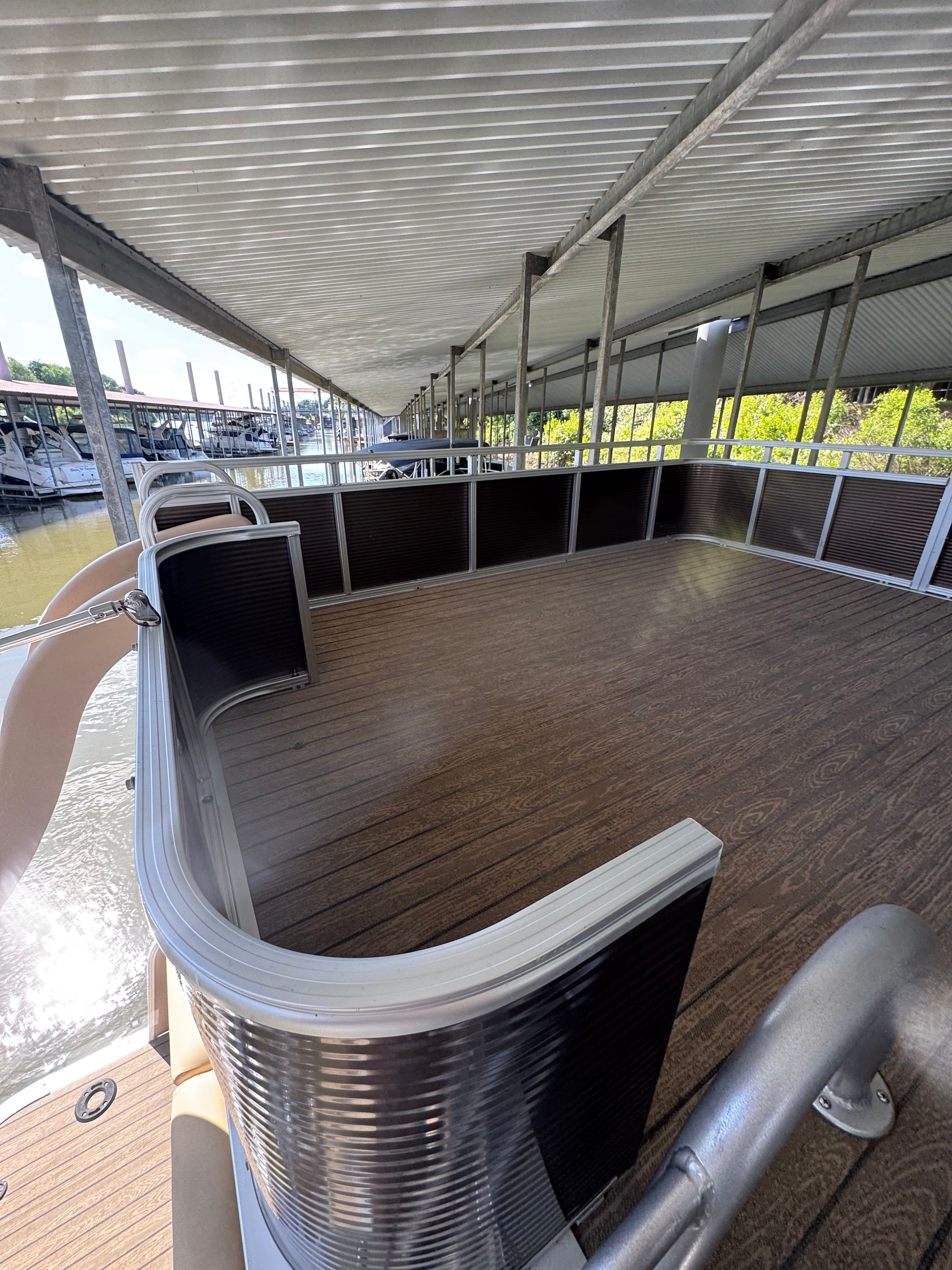 The image shows the spacious deck of a 2019 Avalon Catalina Cruise Funship, docked under a covered area.