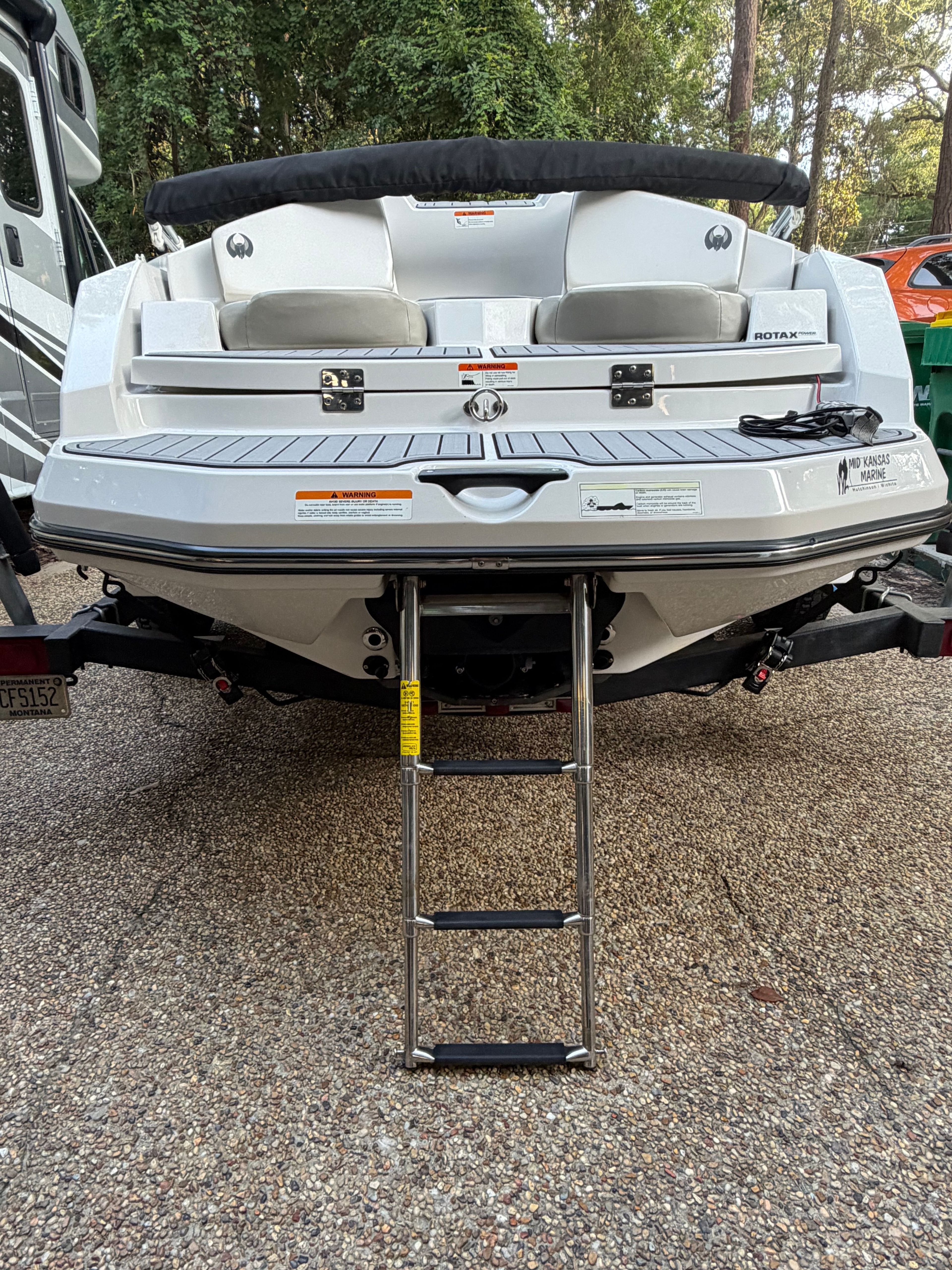 Rear view of a white Scarab 165 boat with a retractable ladder.