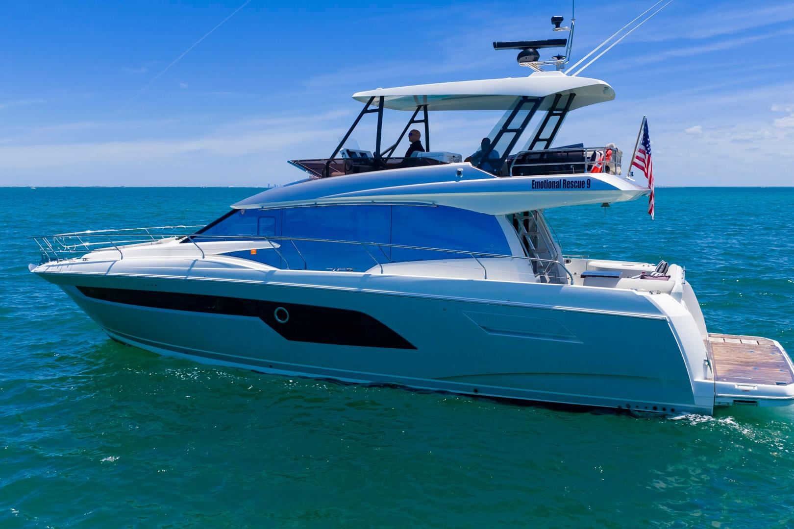 2022 Prestige 520 yacht cruising on clear blue ocean under sunny skies.