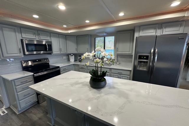 Modern kitchen in 1999 Sumerset 18x82 houseboat with sleek appliances and marble island.