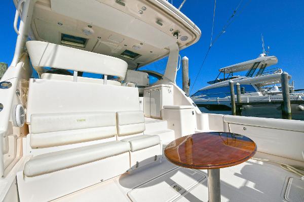2008 Tiara Yachts 4200 Open with spacious seating and table, docked under clear blue sky.