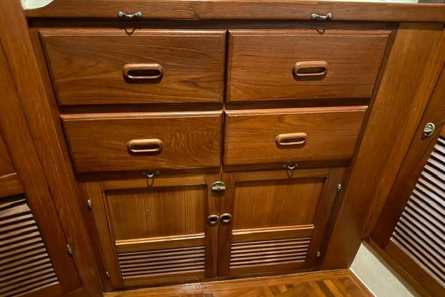 Wooden cabinetry inside a 1986 Kadey-Krogen 42 yacht, featuring drawers and louvered doors.