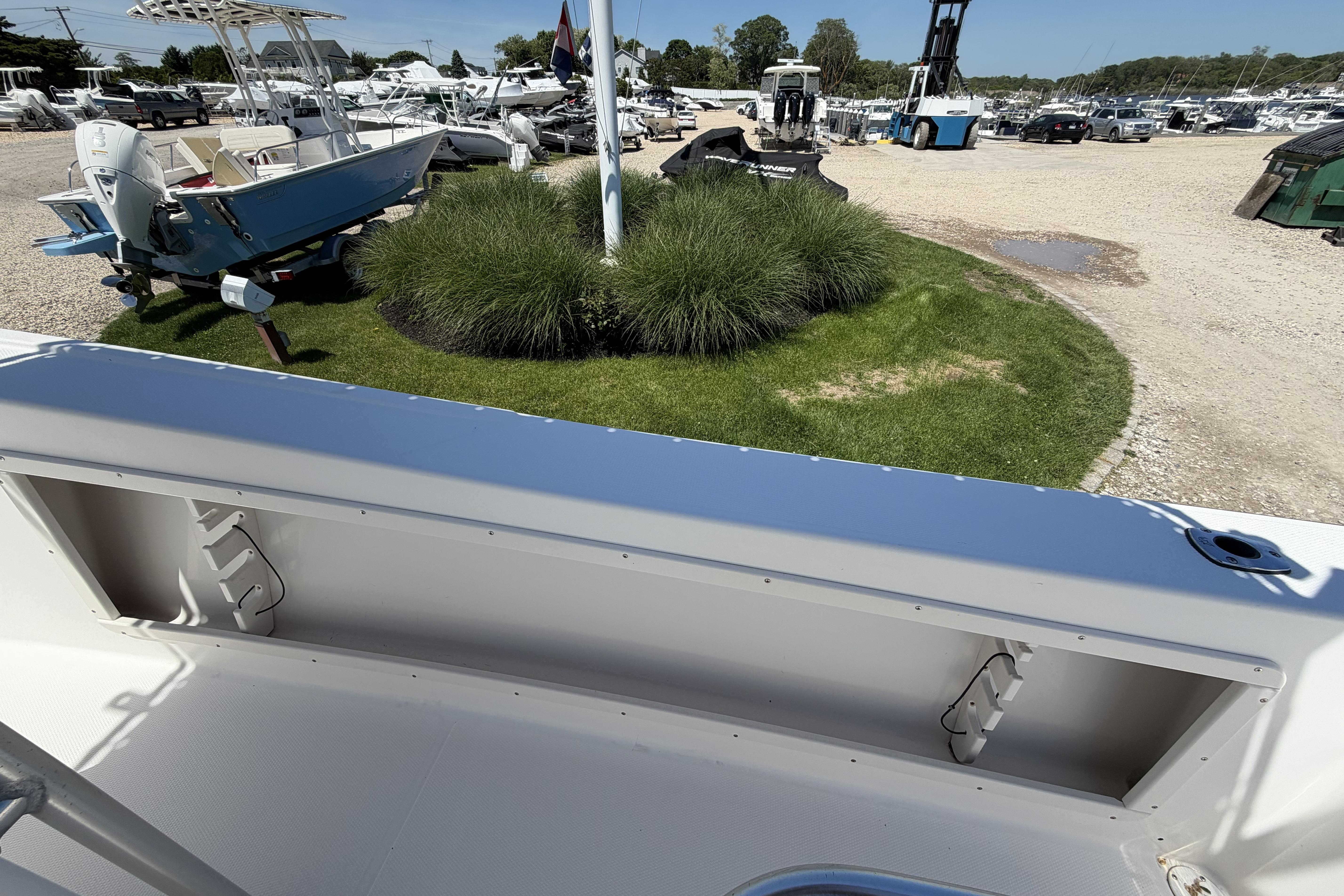 2006 Mako 212 Center Console boat at a marina with grassy landscape.