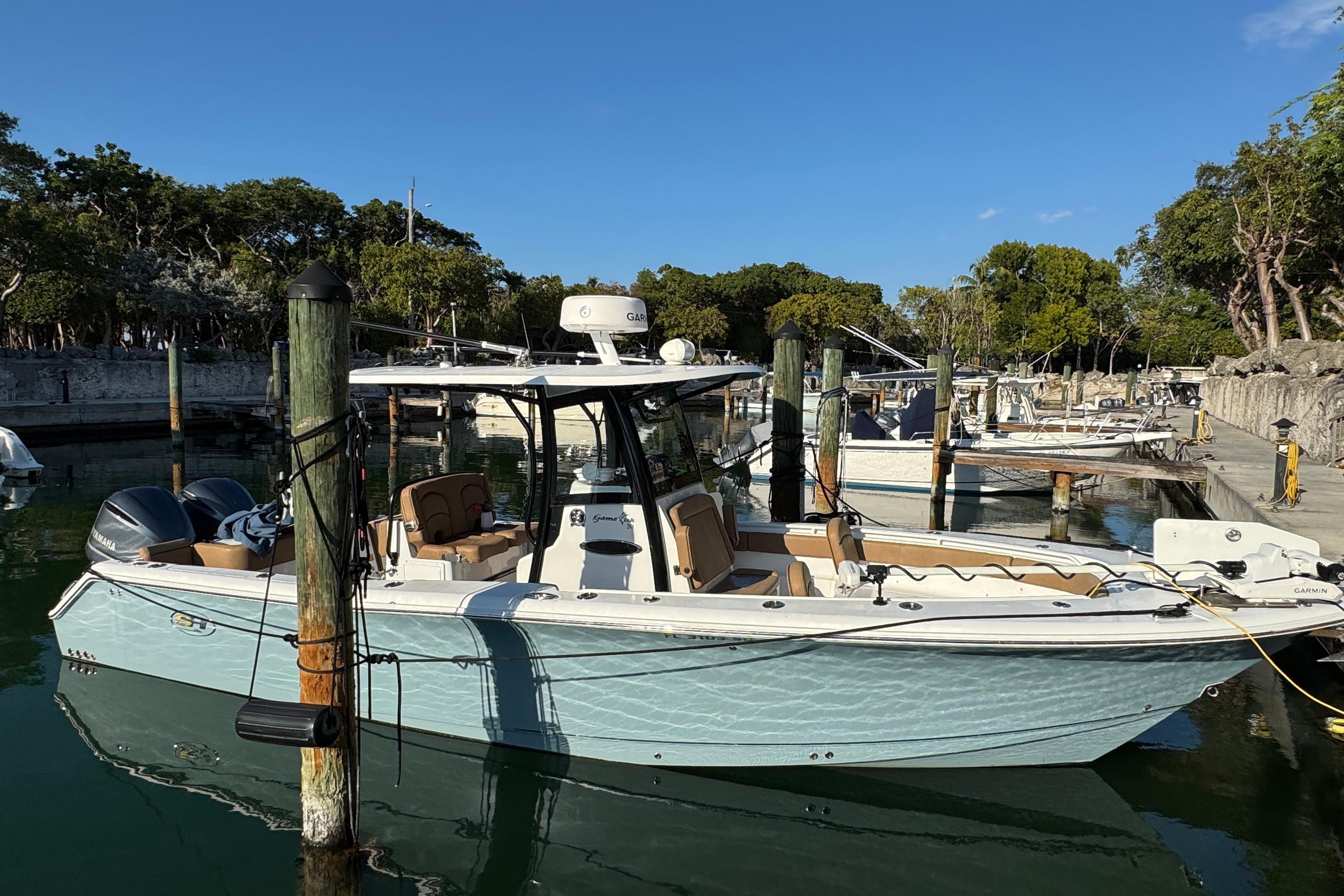 2021 Sea Hunt Gamefish 30 boat docked in a serene marina setting.