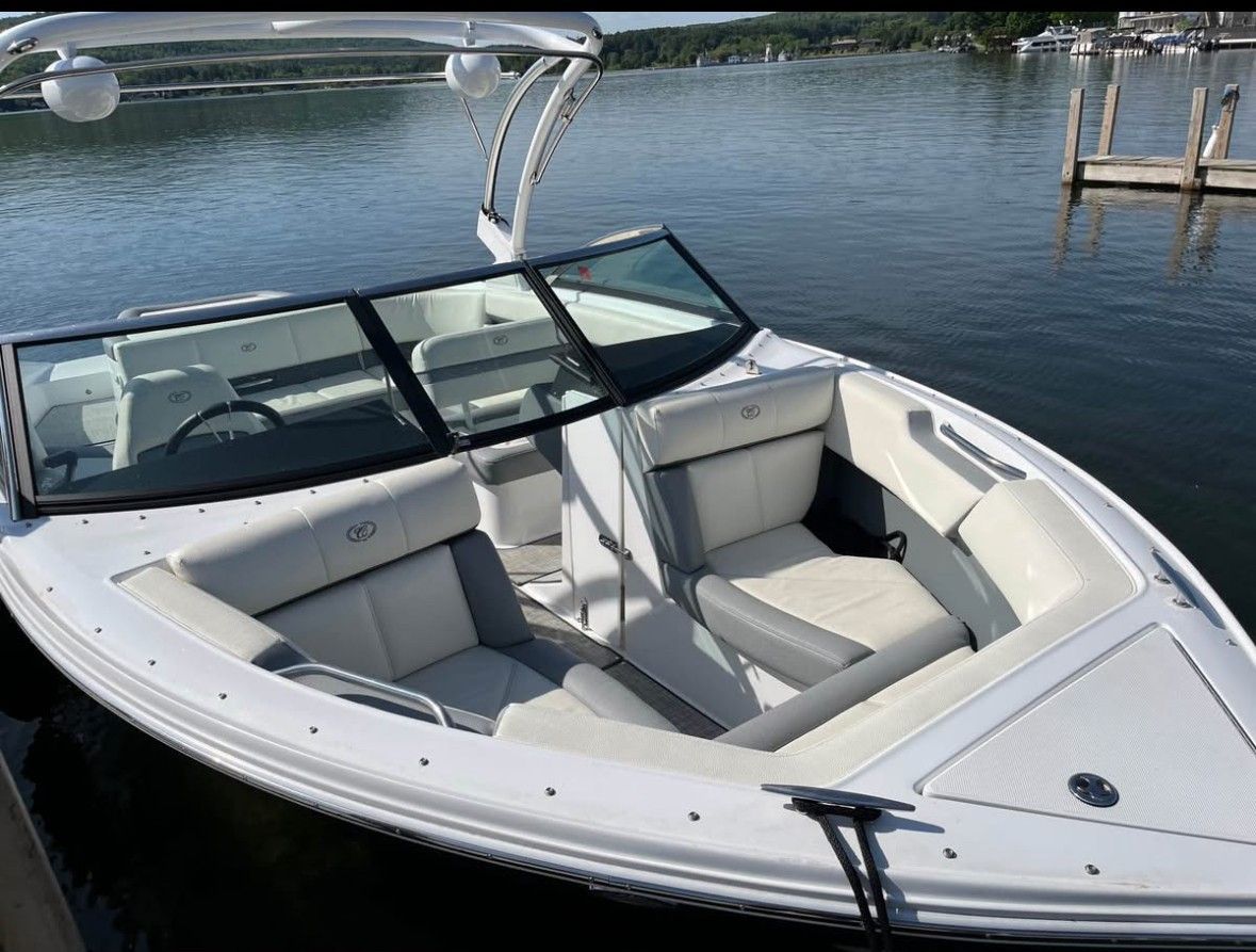 A 2019 Cobalt CS22 boat docked. It features white upholstery and a sleek design.
