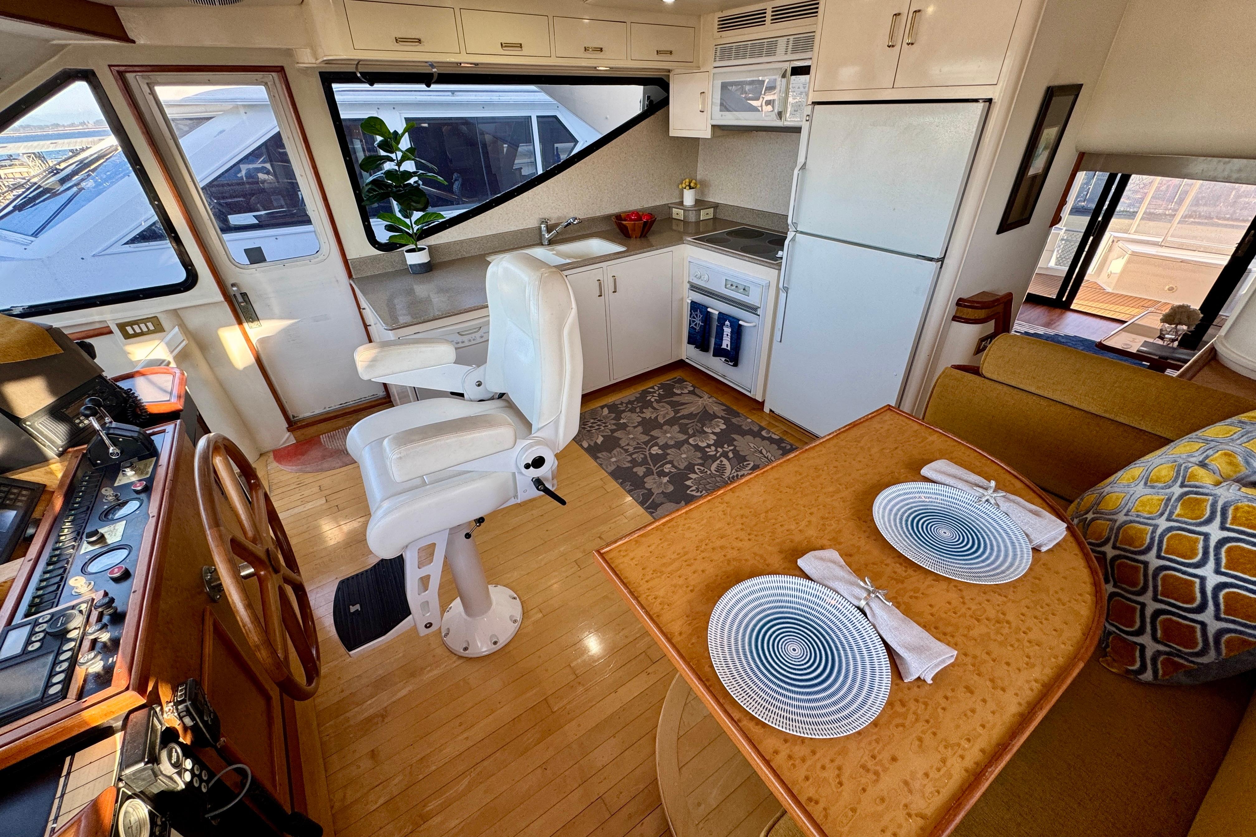 Luxurious 1995 Queenship 62 Pilothouse Motor Yacht interior with helm, kitchen, and dining area.