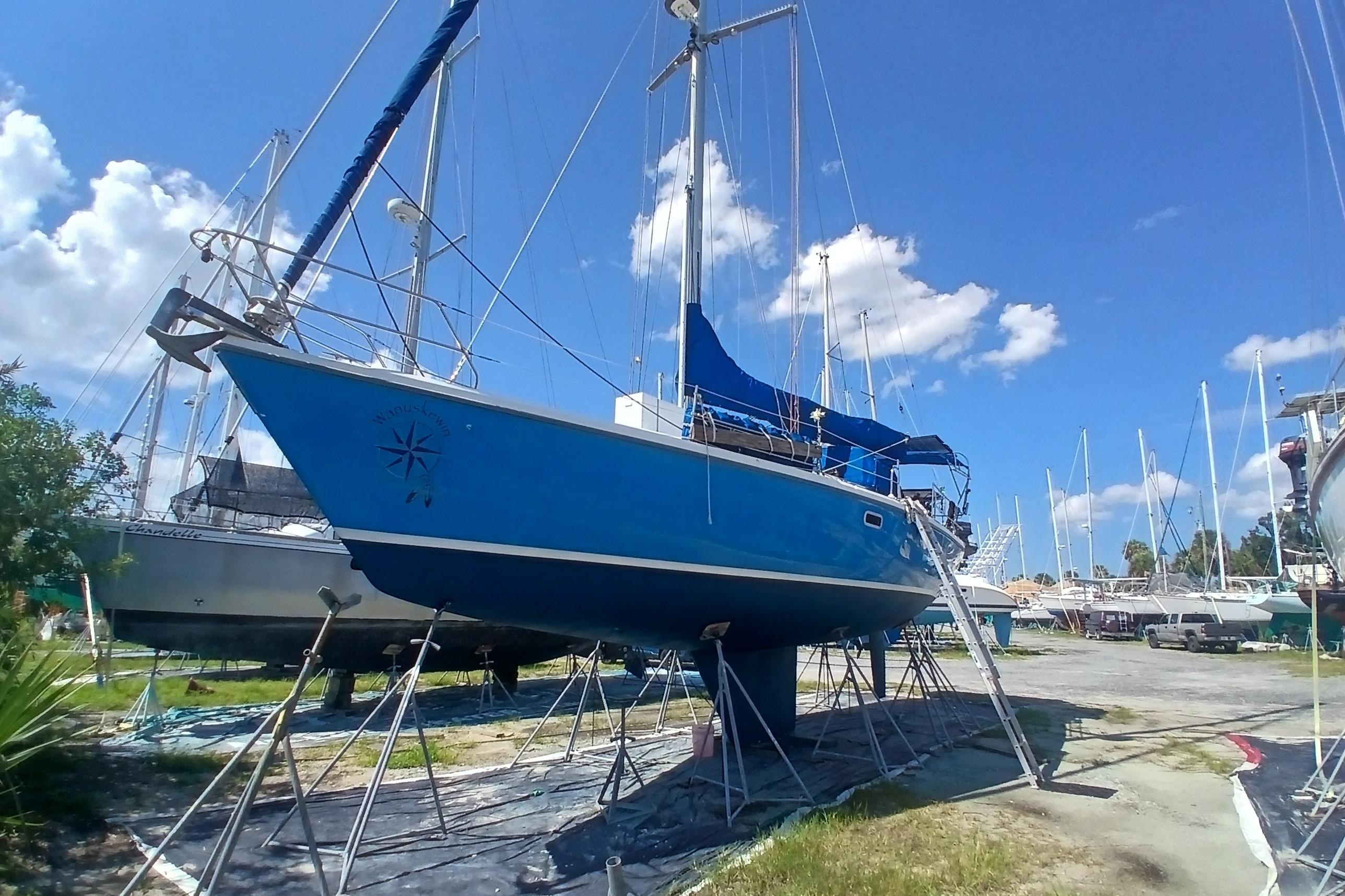1995 Catalina 42 MkII sailboat on stands in a boatyard under a clear blue sky.