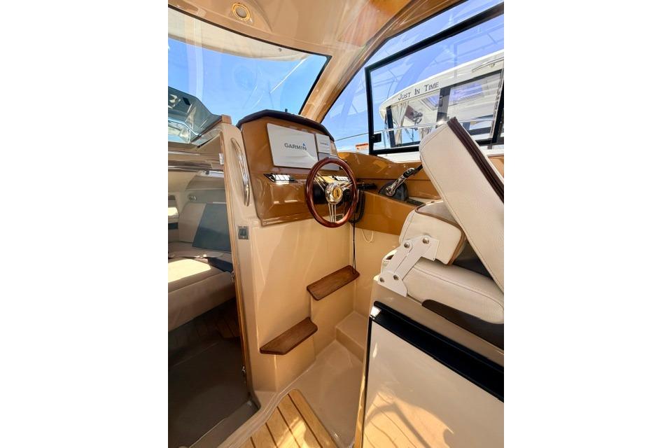 Interior of 2017 Cutwater C-242 Coupe boat with steering wheel and Garmin display.