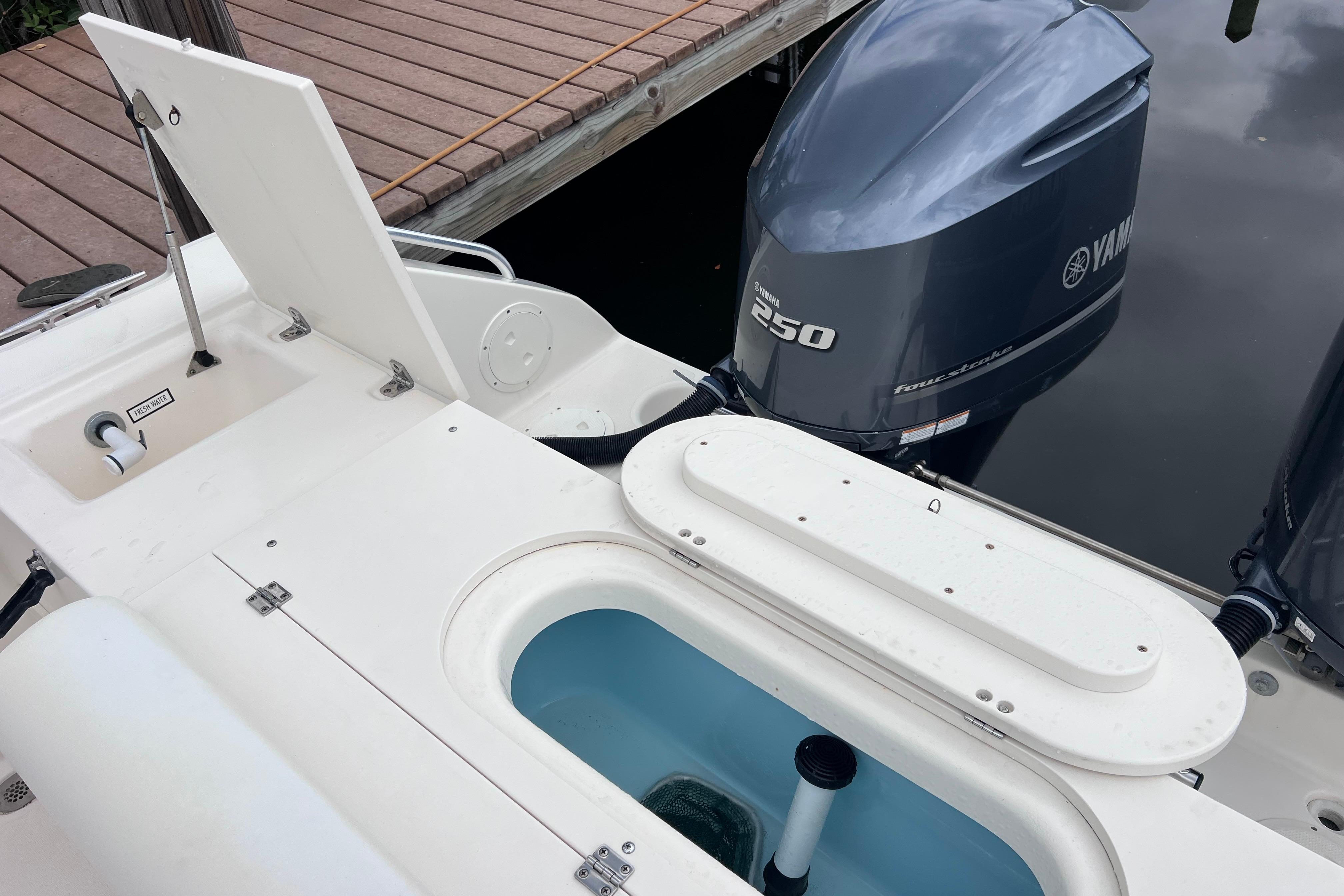 2005 Pursuit 3070 Offshore boat with Yamaha 250 engine, docked by wooden pier.
