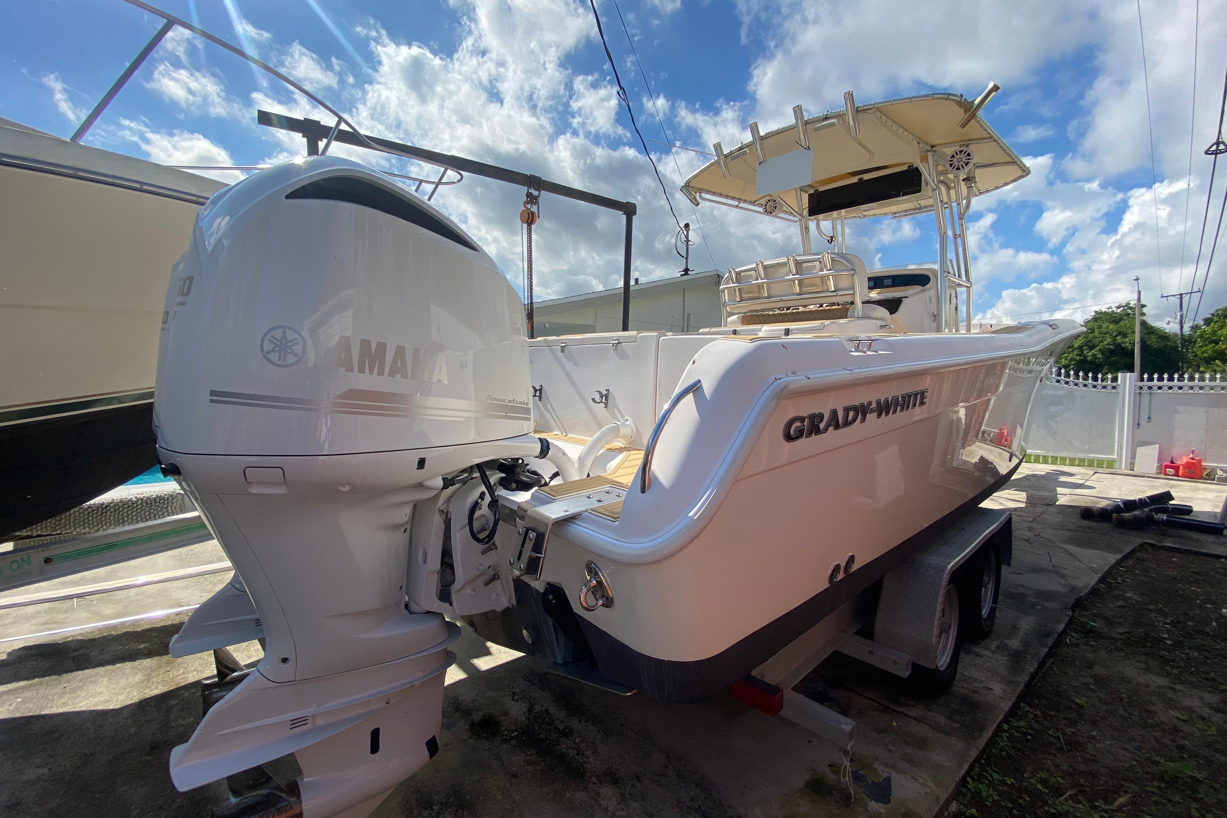 2004 Grady-White Canyon 283 boat with Yamaha outboard motor, parked outdoors under blue sky.