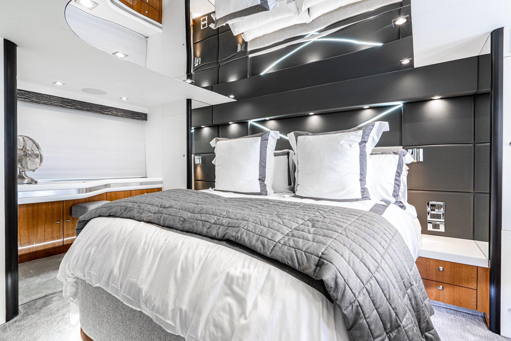 Luxurious bedroom interior of 2021 Sunseeker Predator 68 yacht with modern design elements.