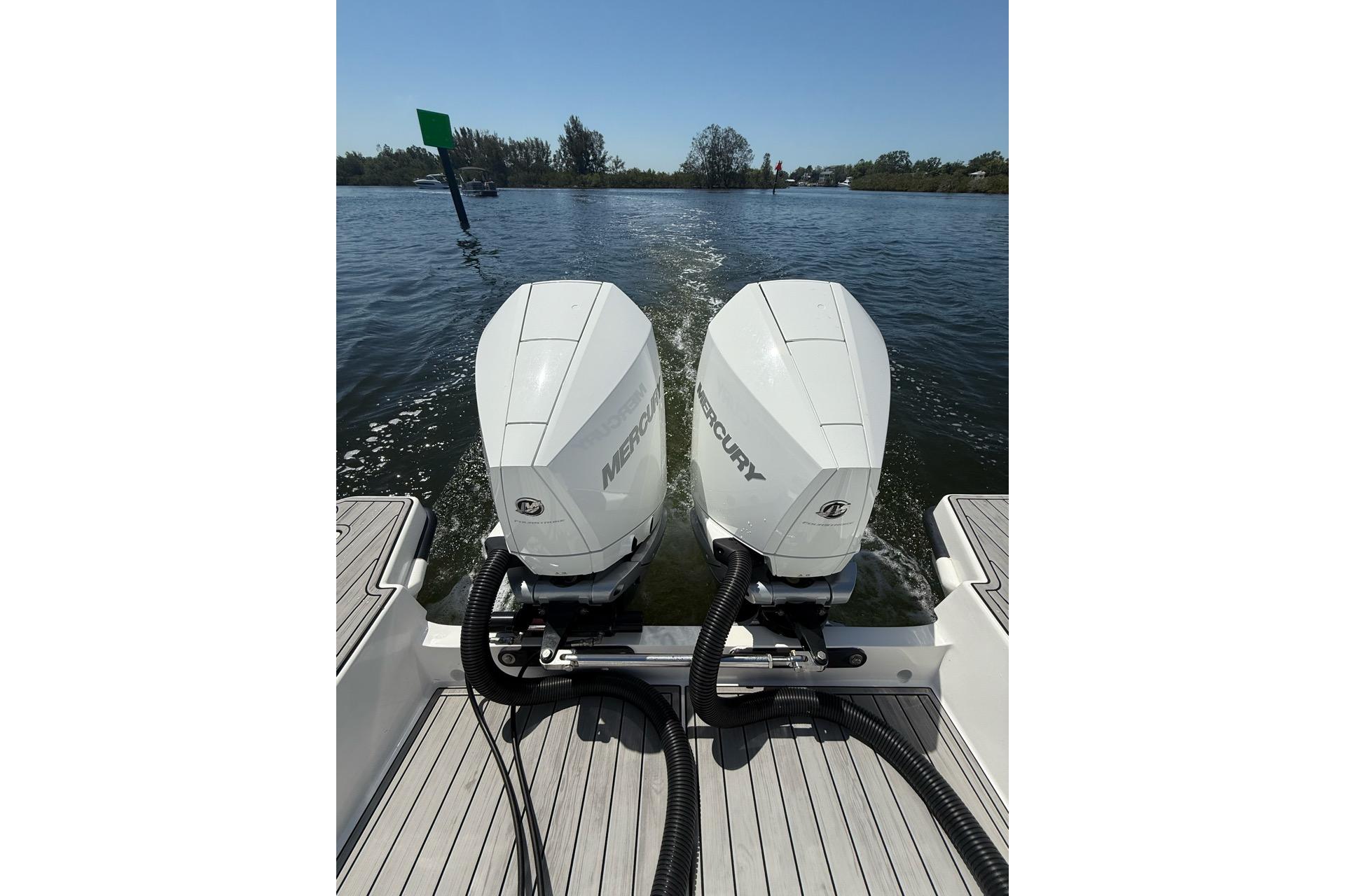 Twin Mercury outboard engines on 2021 Custom Infusion 34 CC boat, cruising on a sunny day.