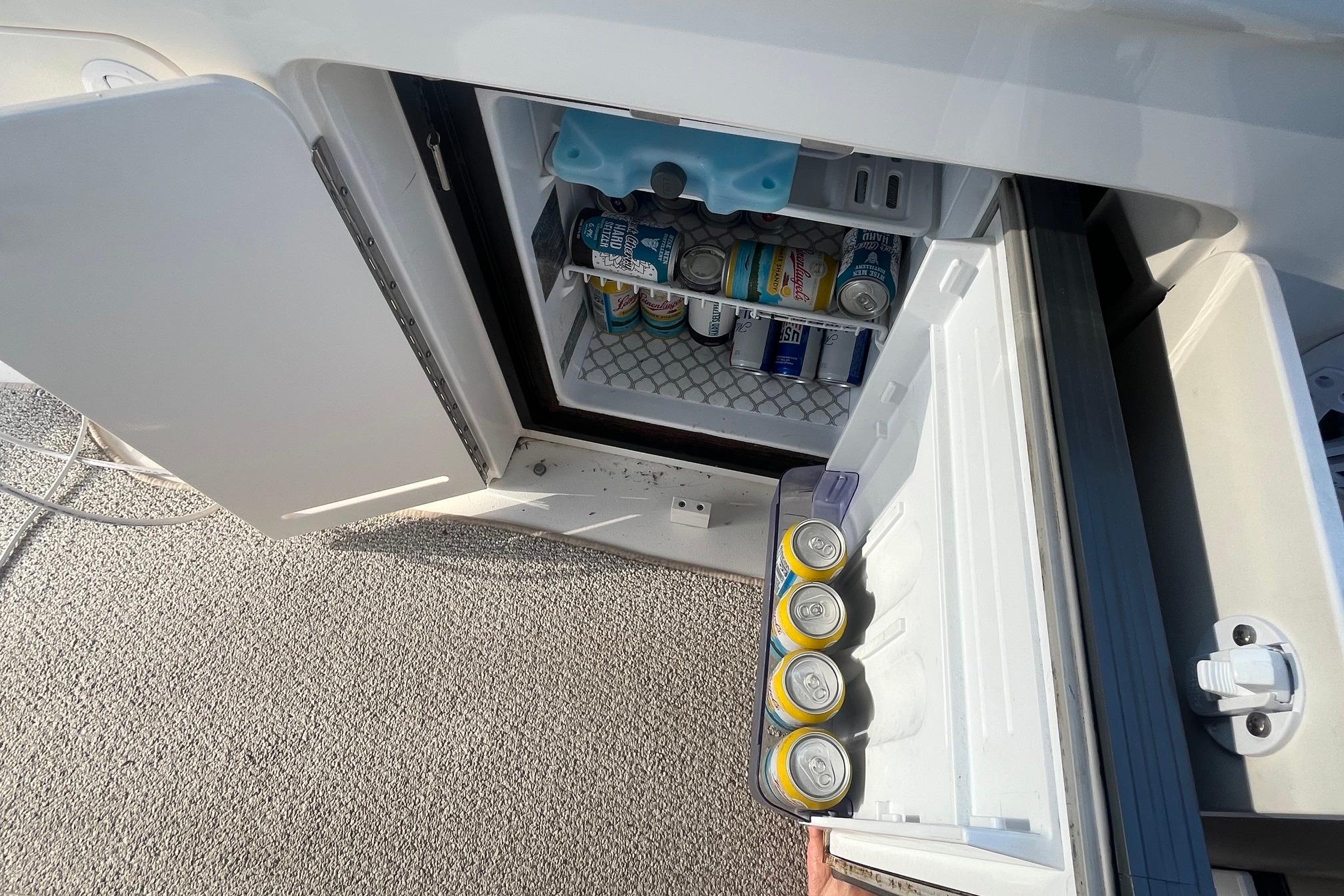Mini fridge stocked with beverages on a 2001 Sea Ray 340 Sundancer boat.