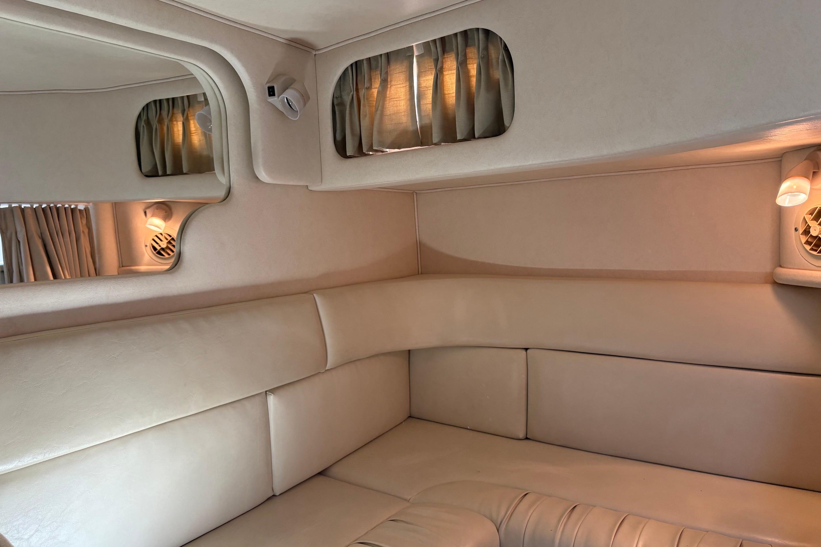 Interior of 2001 Sea Ray 340 Sundancer yacht with beige seating and ambient lighting.
