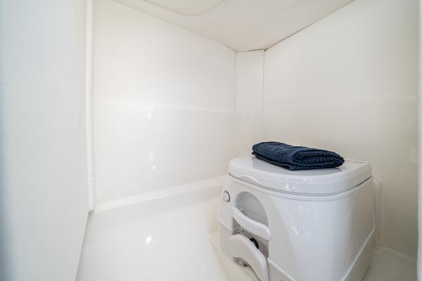 Manufacturer Provided Image: Compact bathroom in 2023 Sea Ray SPX 230 OB boat with portable toilet.