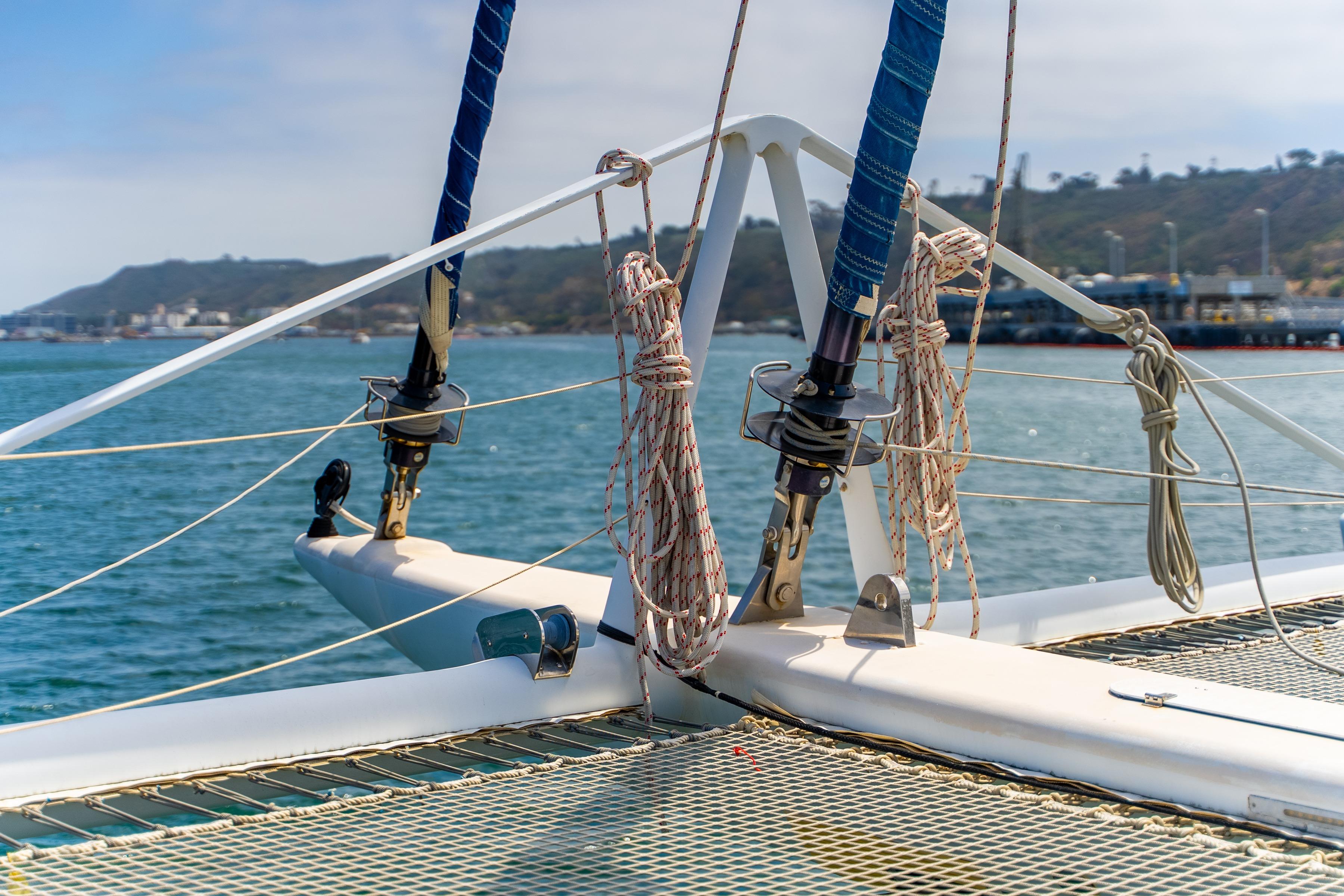 Catamaran deck view, Catana 65, 2009 model, with ropes and netting, coastal background.