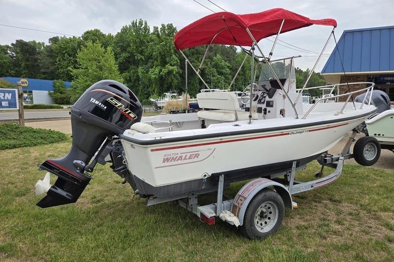 1996 Boston Whaler Outrage 17 boat with red canopy on trailer, Yamaha engine visible.