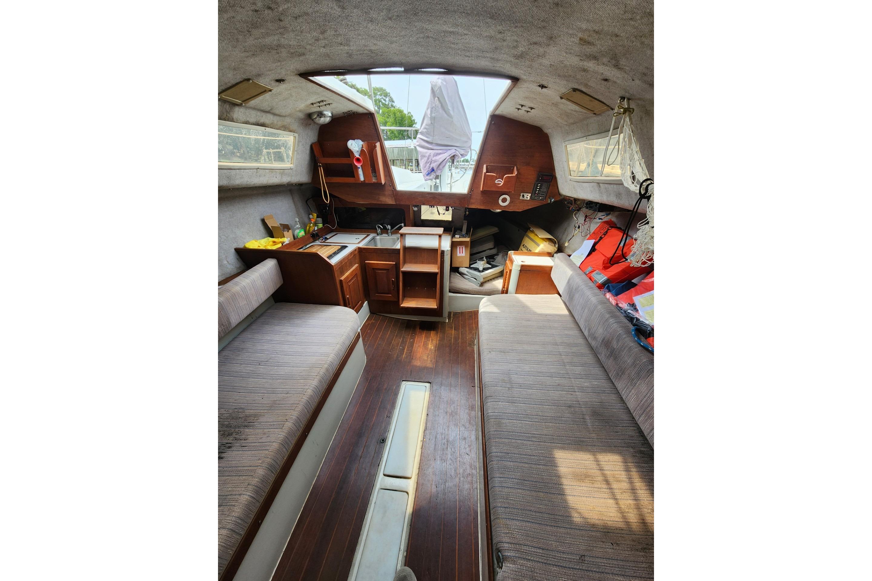 Interior of a 1988 O'Day 272 LE sailboat, featuring cozy seating and a compact kitchen area.