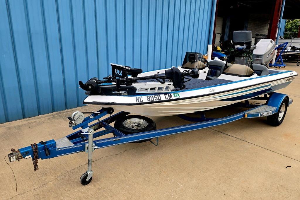 1996 Champion 181 SX boat on trailer, parked by blue building.