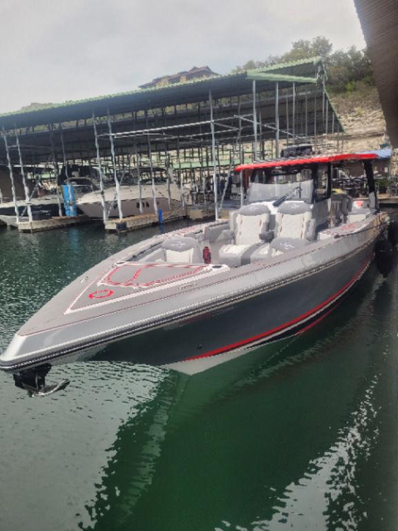 2024 Fountain 38 SCX boat docked in marina, featuring sleek design and modern amenities.