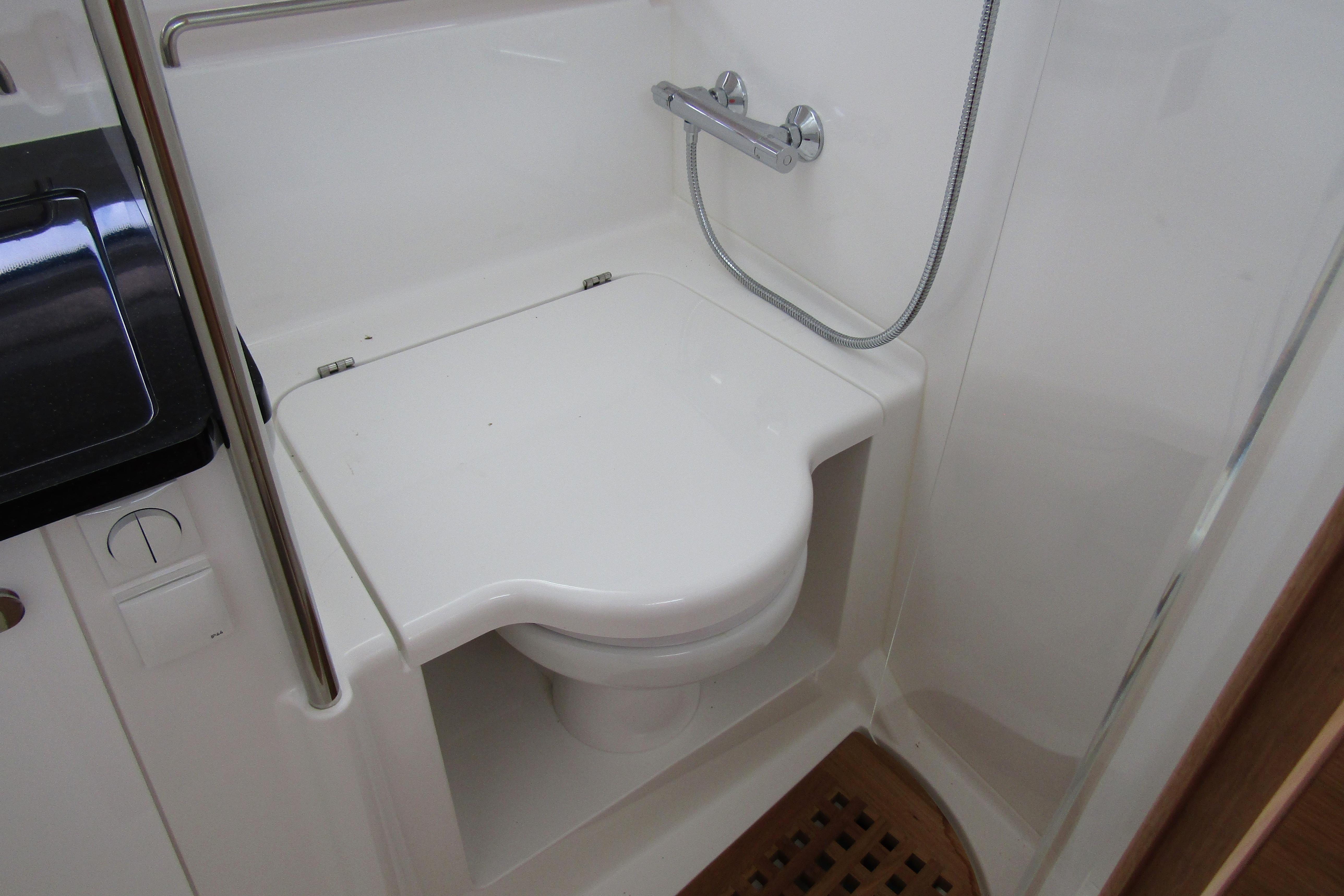 Compact bathroom with shower and toilet on 2025 Nimbus Tender 11 boat.