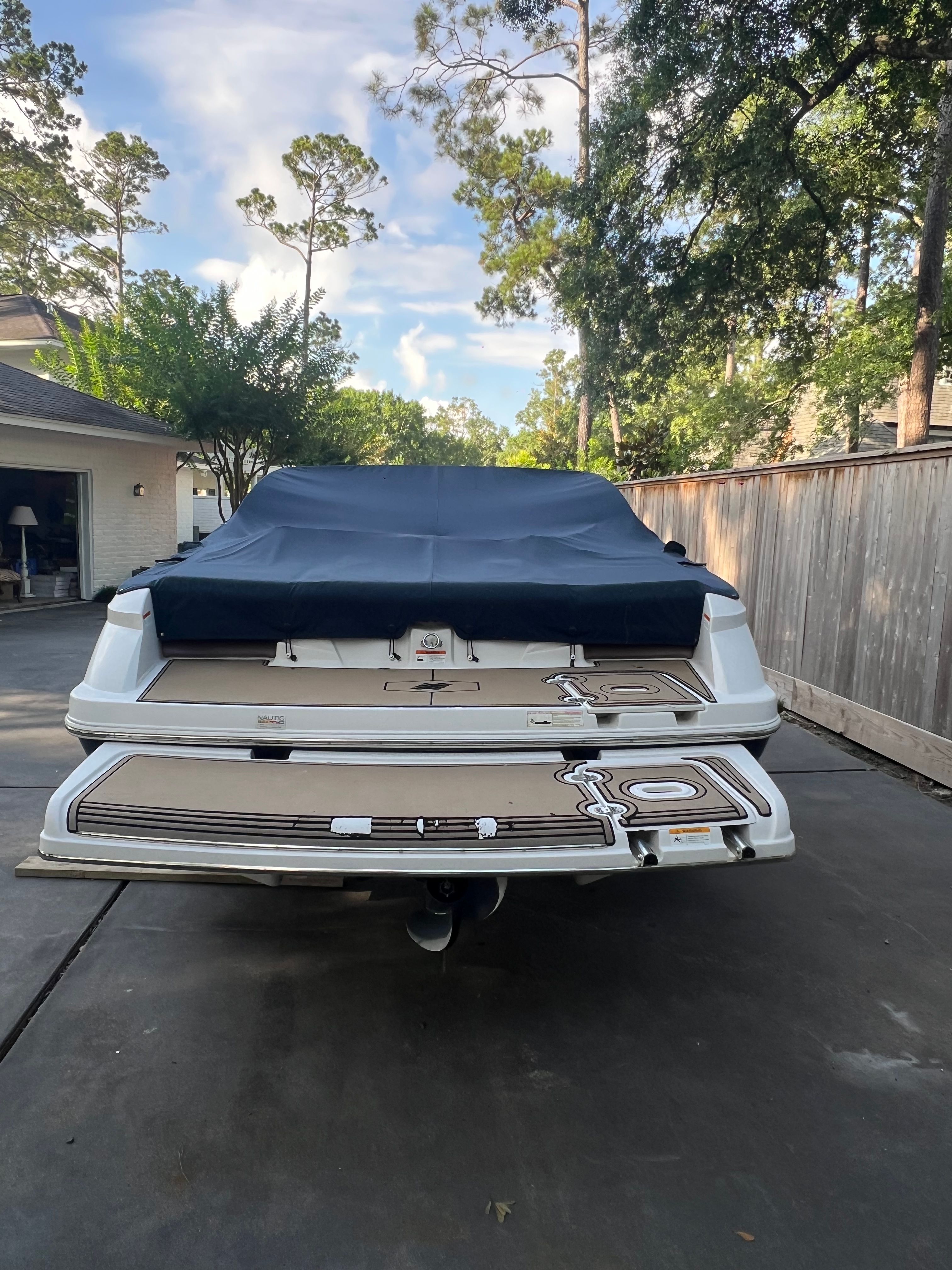 2017 Four Winns H230 boat with cover parked outdoors.