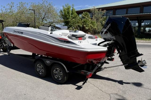 2026 Tahoe T21 boat with red hull on trailer, parked outdoors.