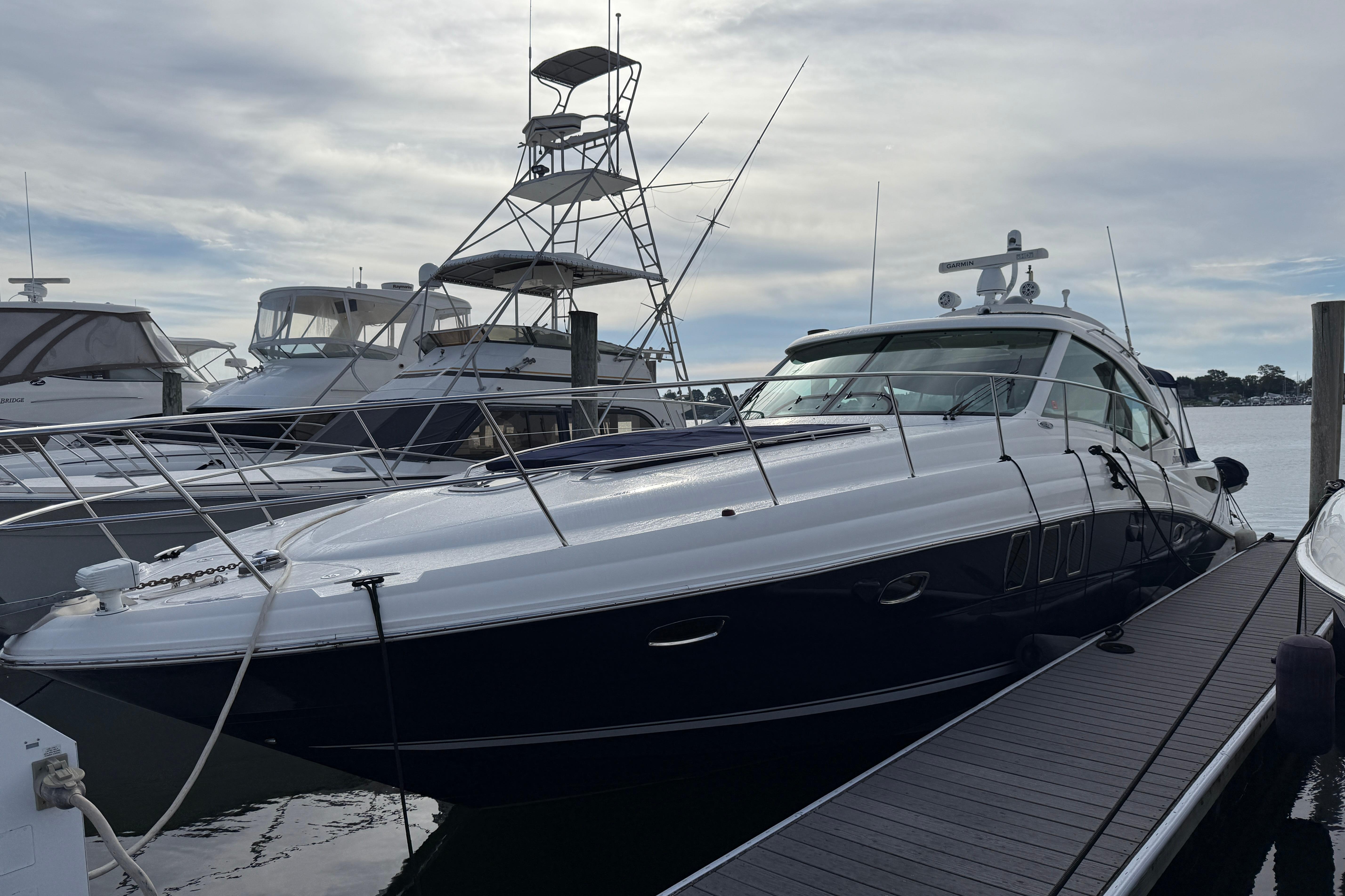 2006 Sea Ray 48 Sundancer yacht docked at marina under cloudy sky.