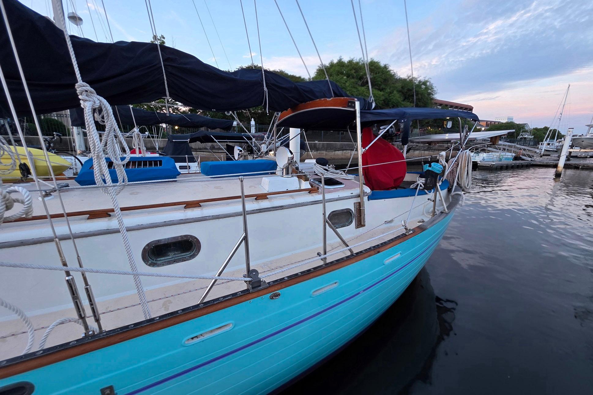 1982 Tayana 37 sailboat docked, featuring turquoise hull and classic design elements.