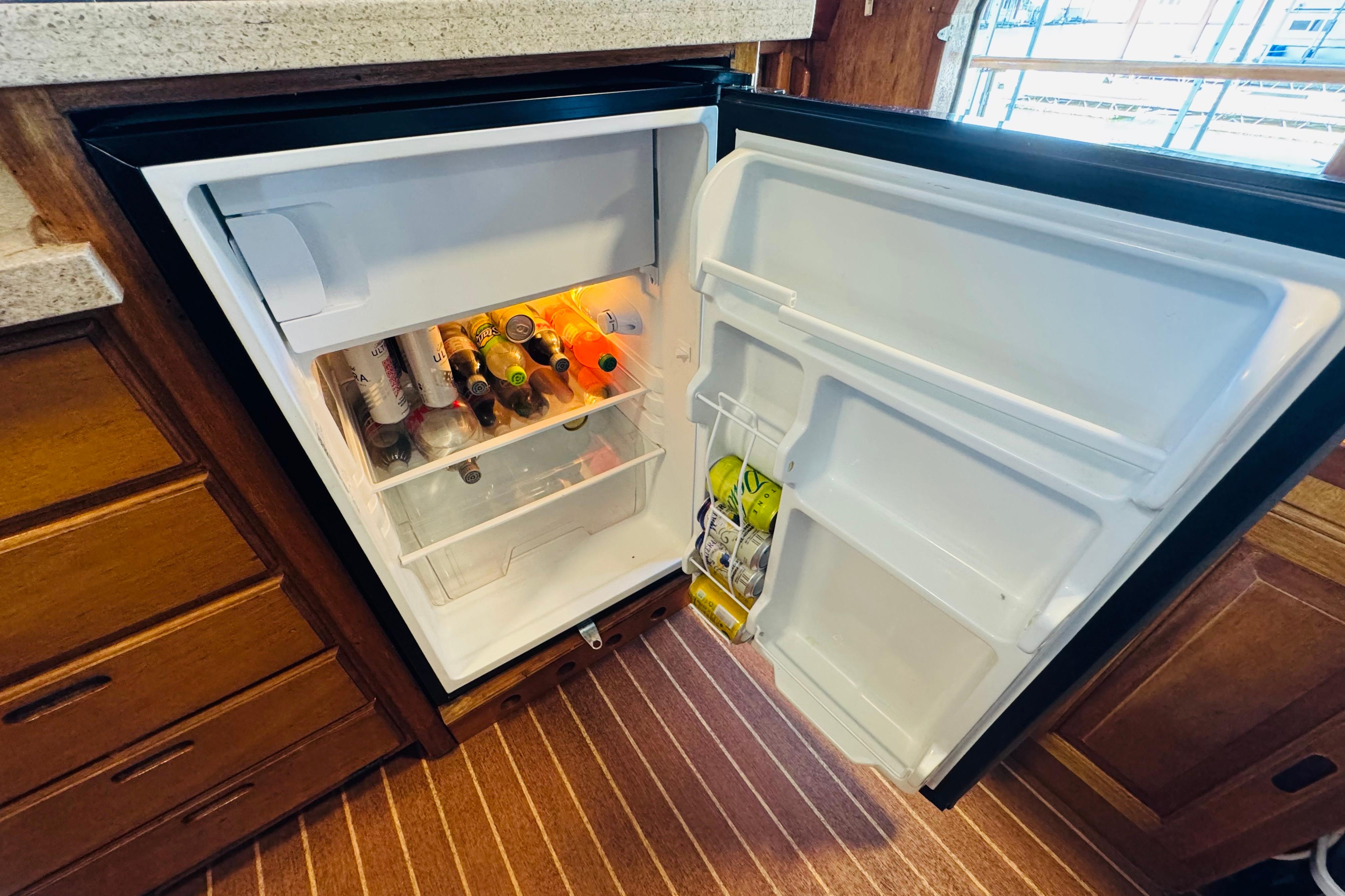 Open fridge in 1978 Californian 42 LRC boat, stocked with beverages and condiments.