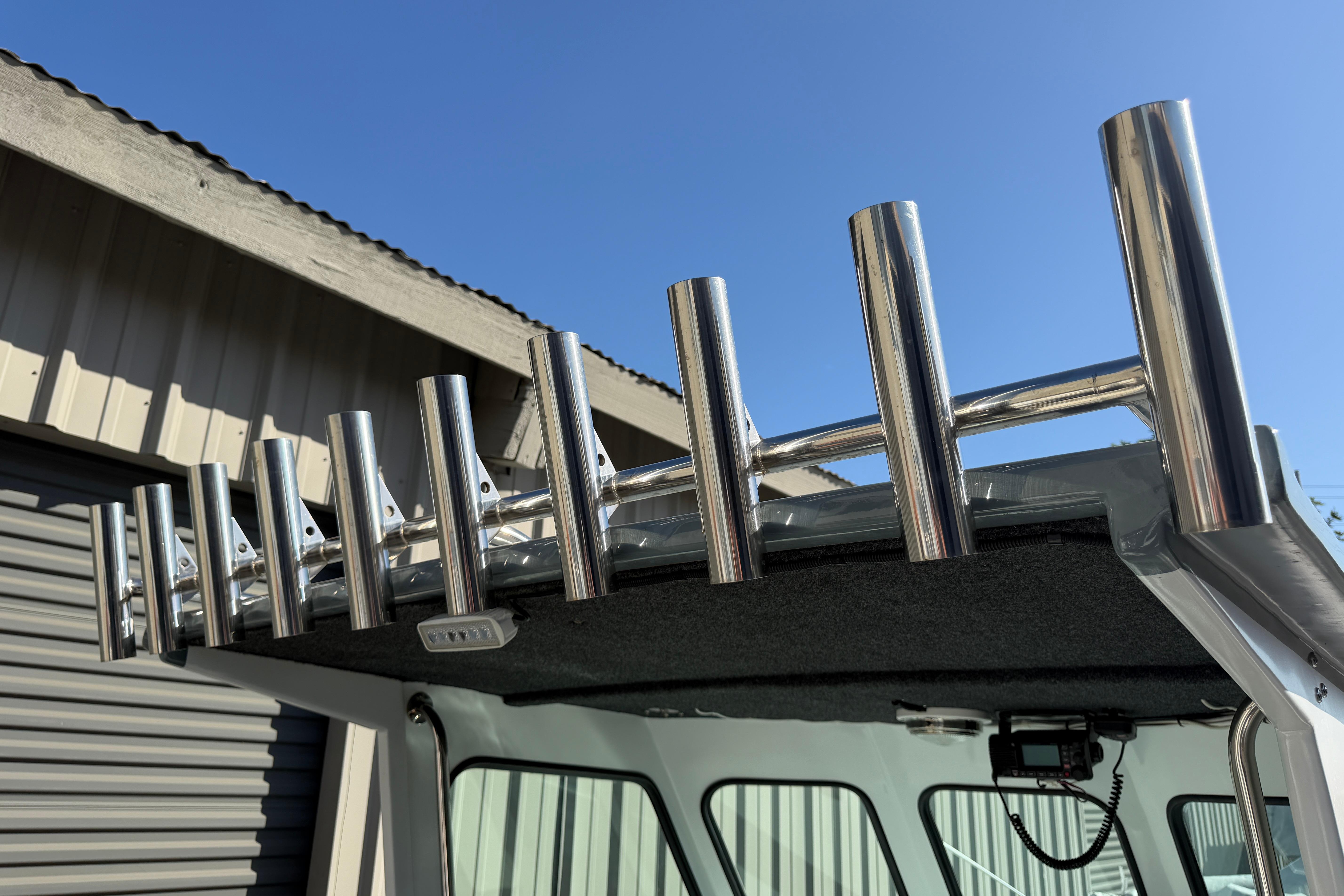 Stainless steel rod holders on 1986 Radon 21 Sport boat under clear blue sky.