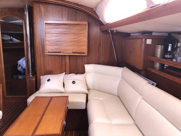 Interior of 2001 Jeanneau 45.2 yacht with white leather seating and wooden accents.