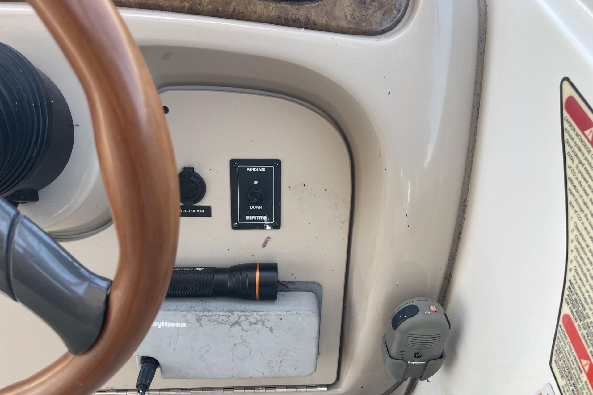 Control panel of a 2000 Sea Ray Sundancer 260 boat with steering wheel and switches.