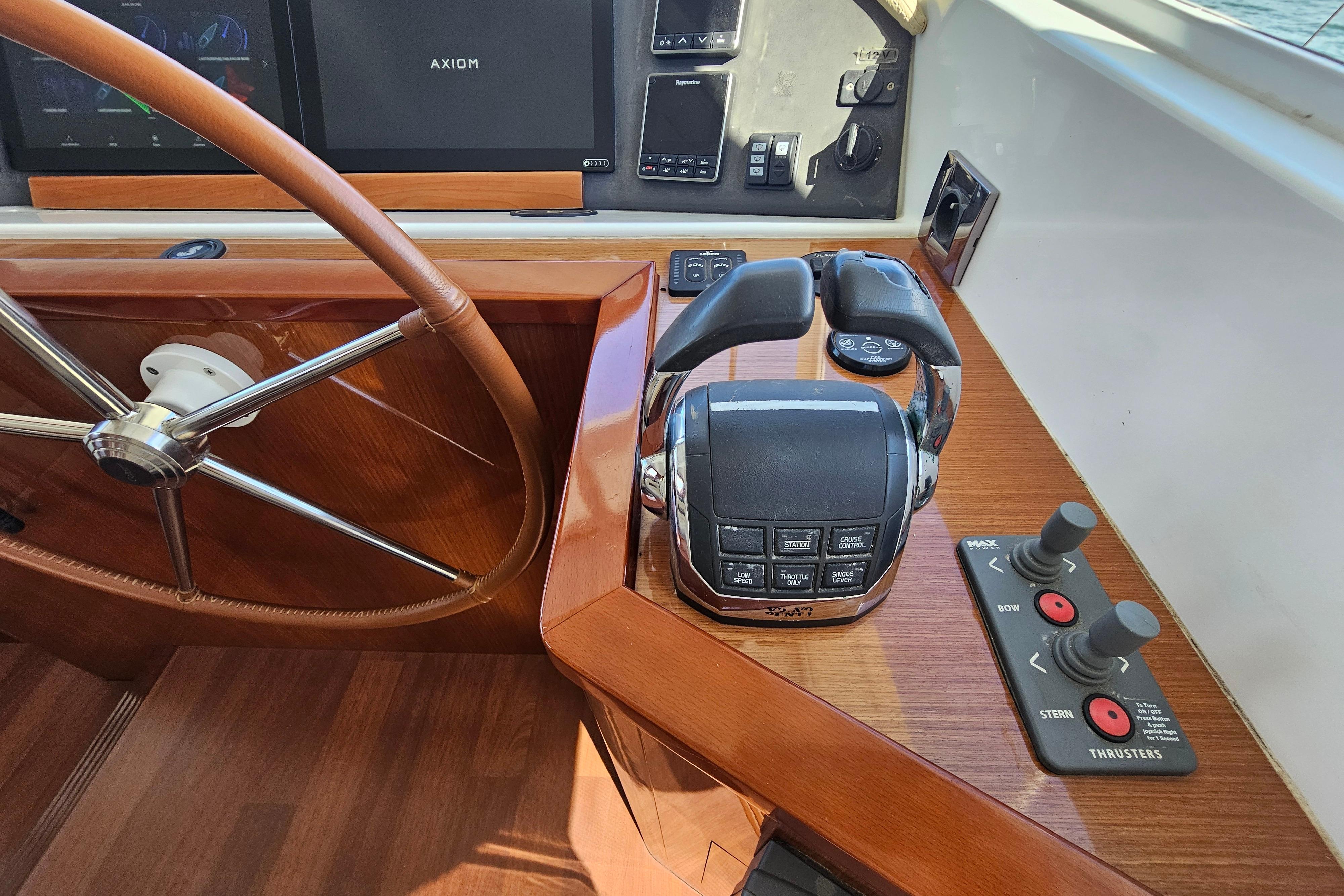 Helm controls of a 2011 Beneteau Swift Trawler 52 with steering wheel and throttle.
