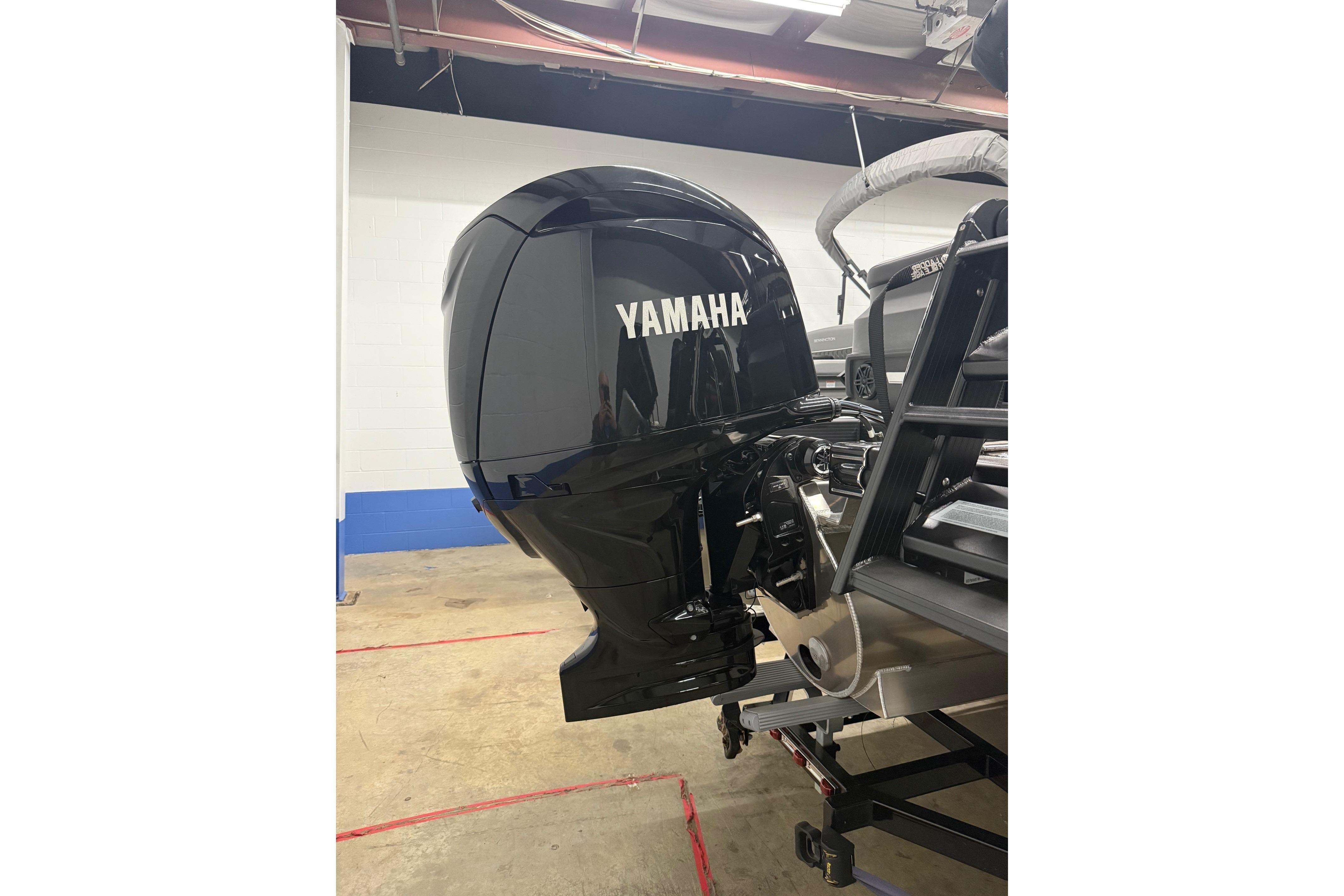 2025 Bennington M Line boat with Yamaha outboard motor in a garage setting.