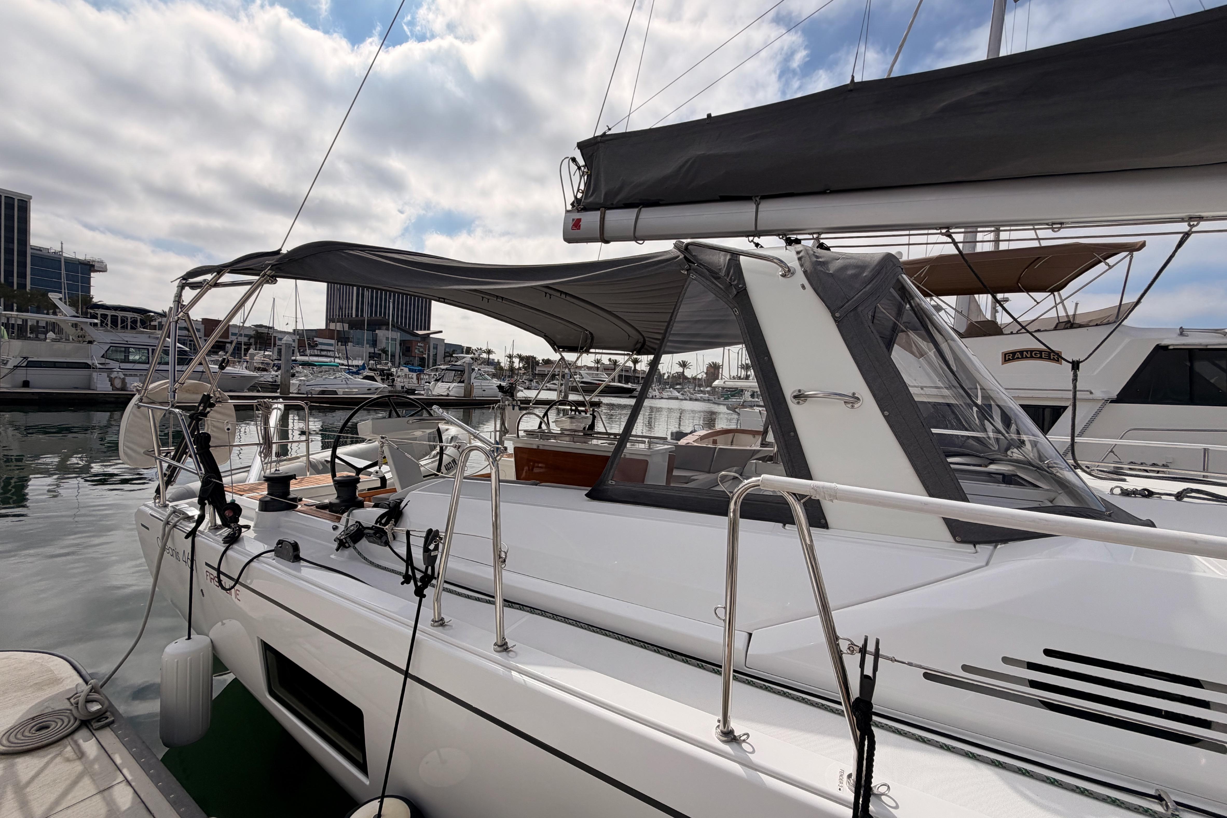 2020 Beneteau Oceanis 46.1 sailboat docked at marina under cloudy sky.