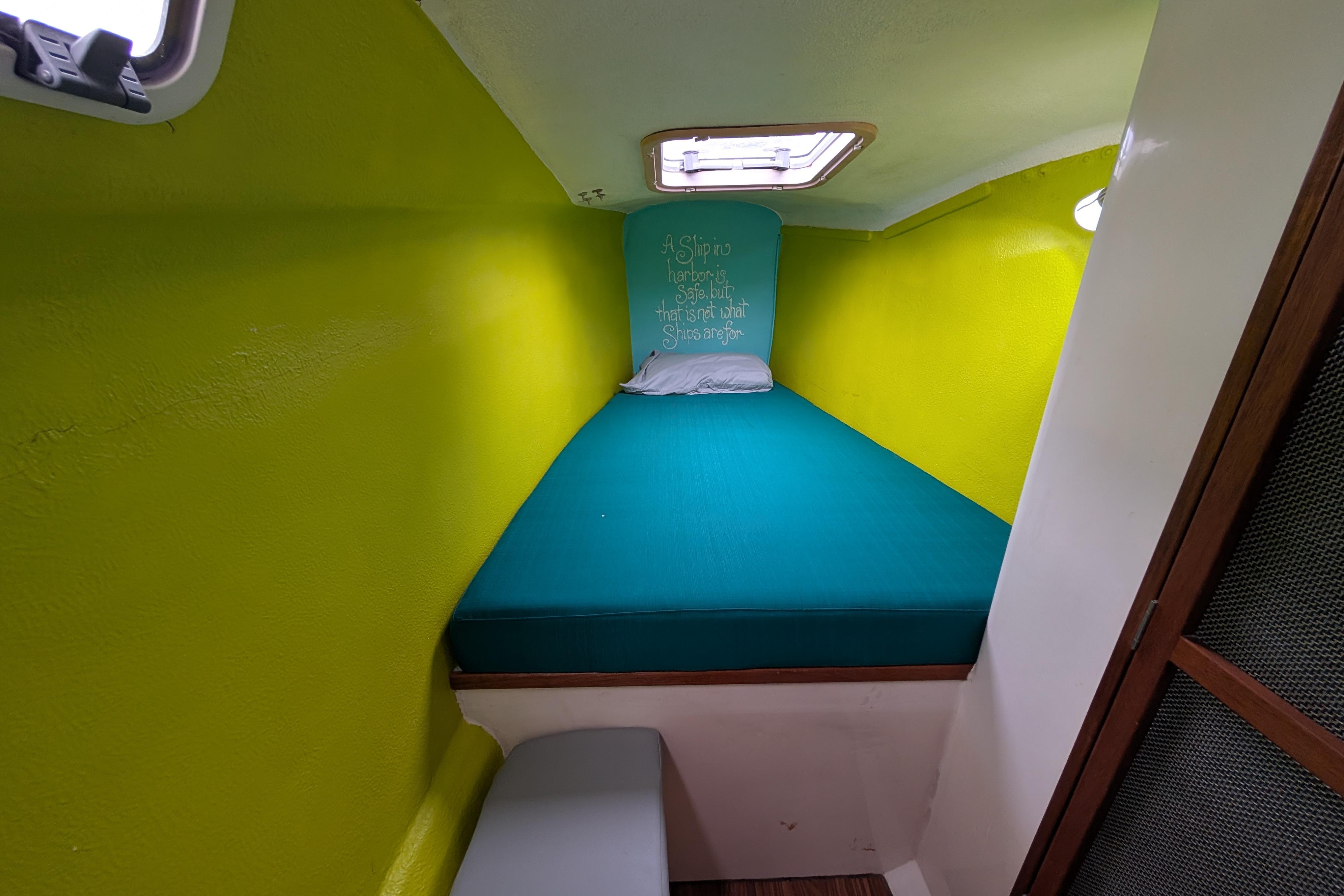 Cozy cabin interior of 1999 Island Spirit 37 sailboat with vibrant green walls.