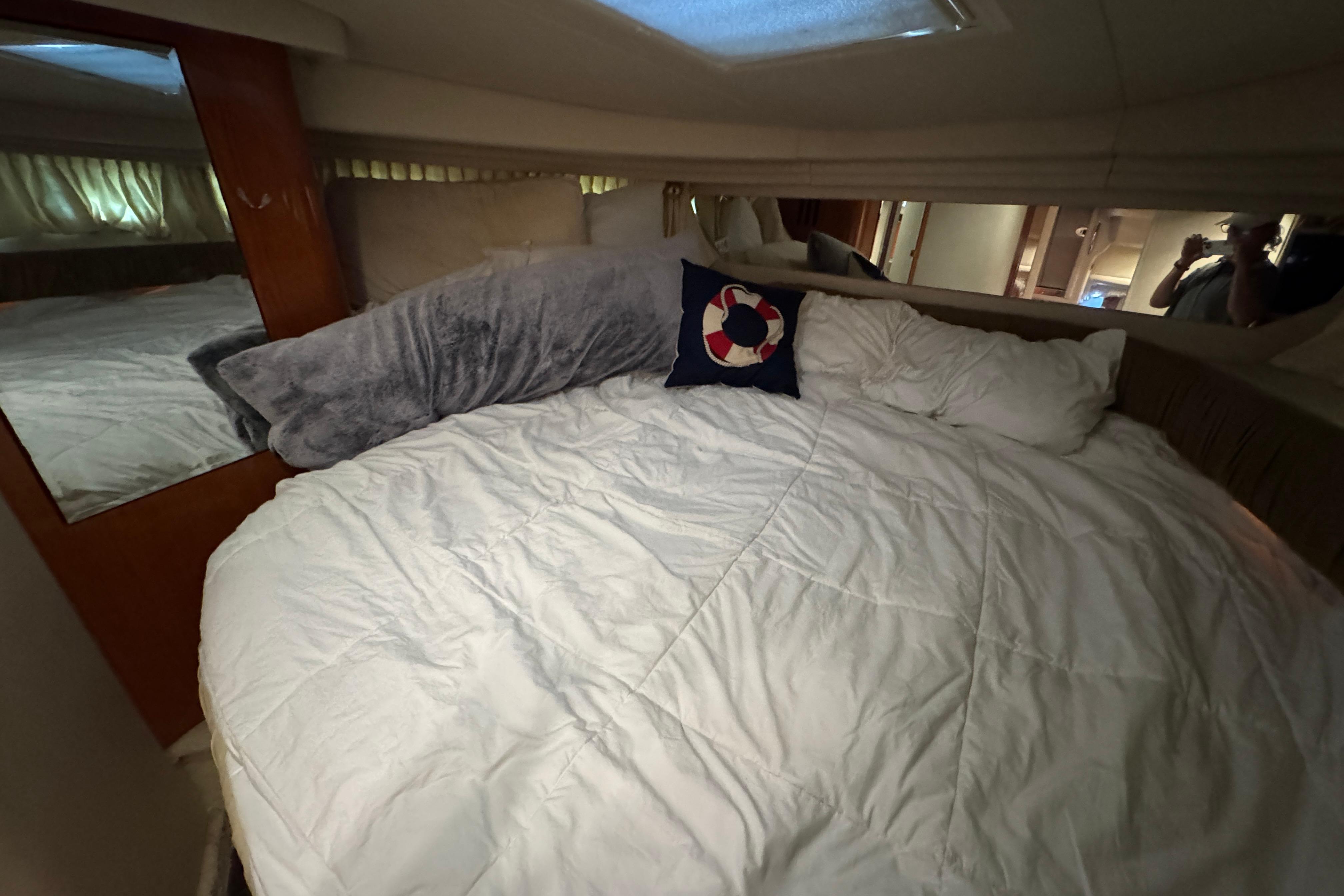 Cozy cabin interior of 2001 Sea Ray 380 Sundancer with plush bedding and nautical decor.