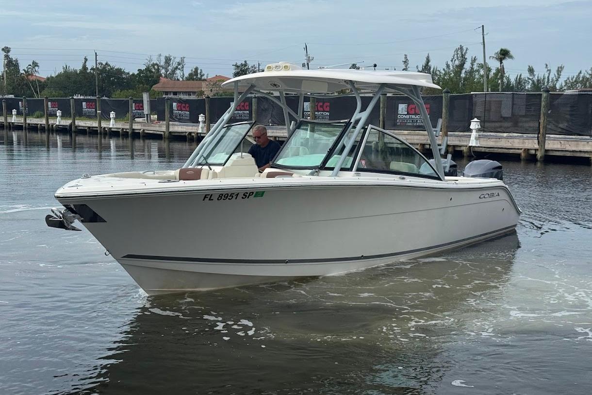 2020 Cobia 280 Dual Console boat navigating a calm marina.