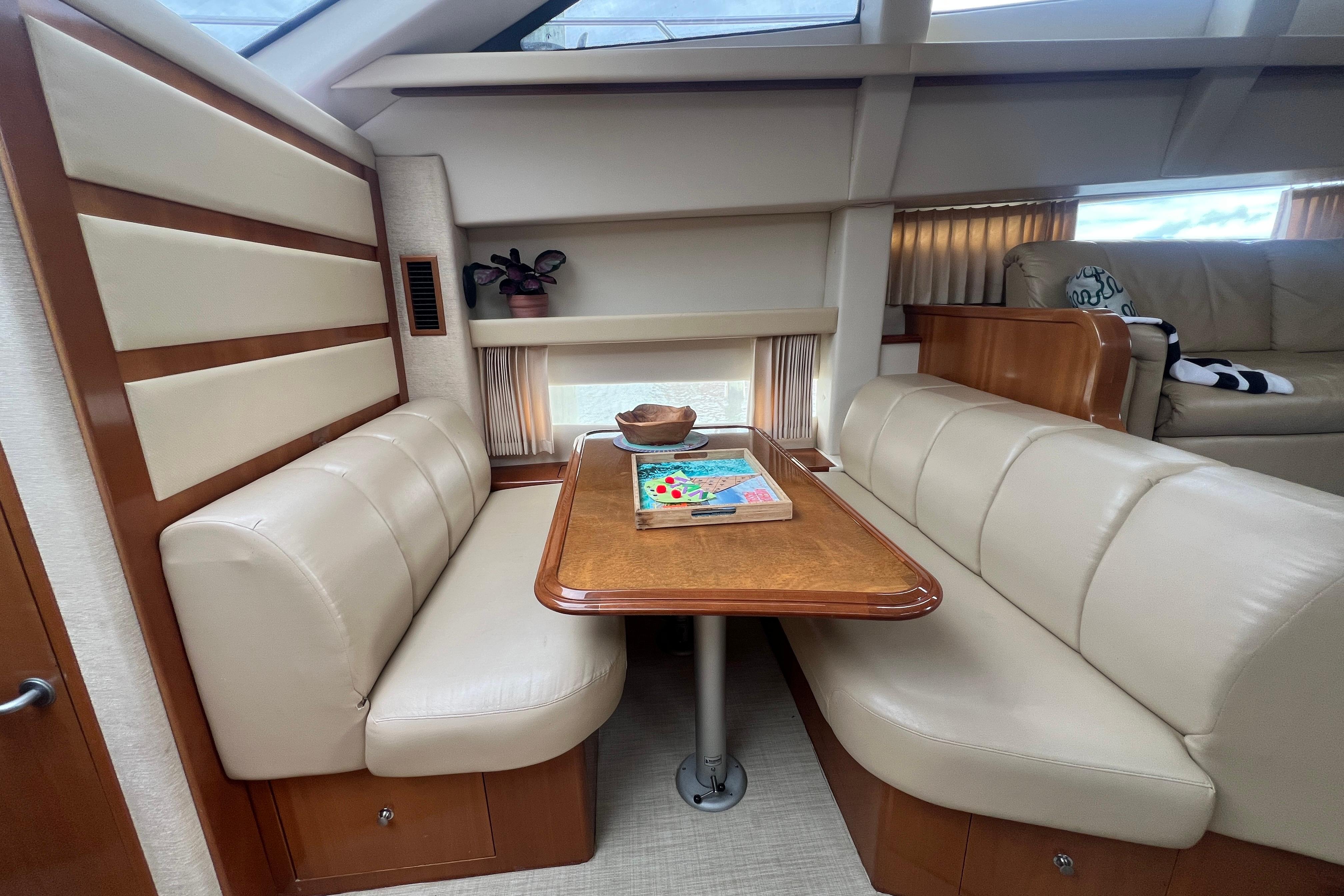 Interior of 2006 Carver 43 Motor Yacht with beige seating and wooden table.
