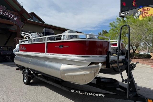 2026 Sun Tracker Bass Buggy 18 DLX pontoon boat on trailer, parked outdoors.